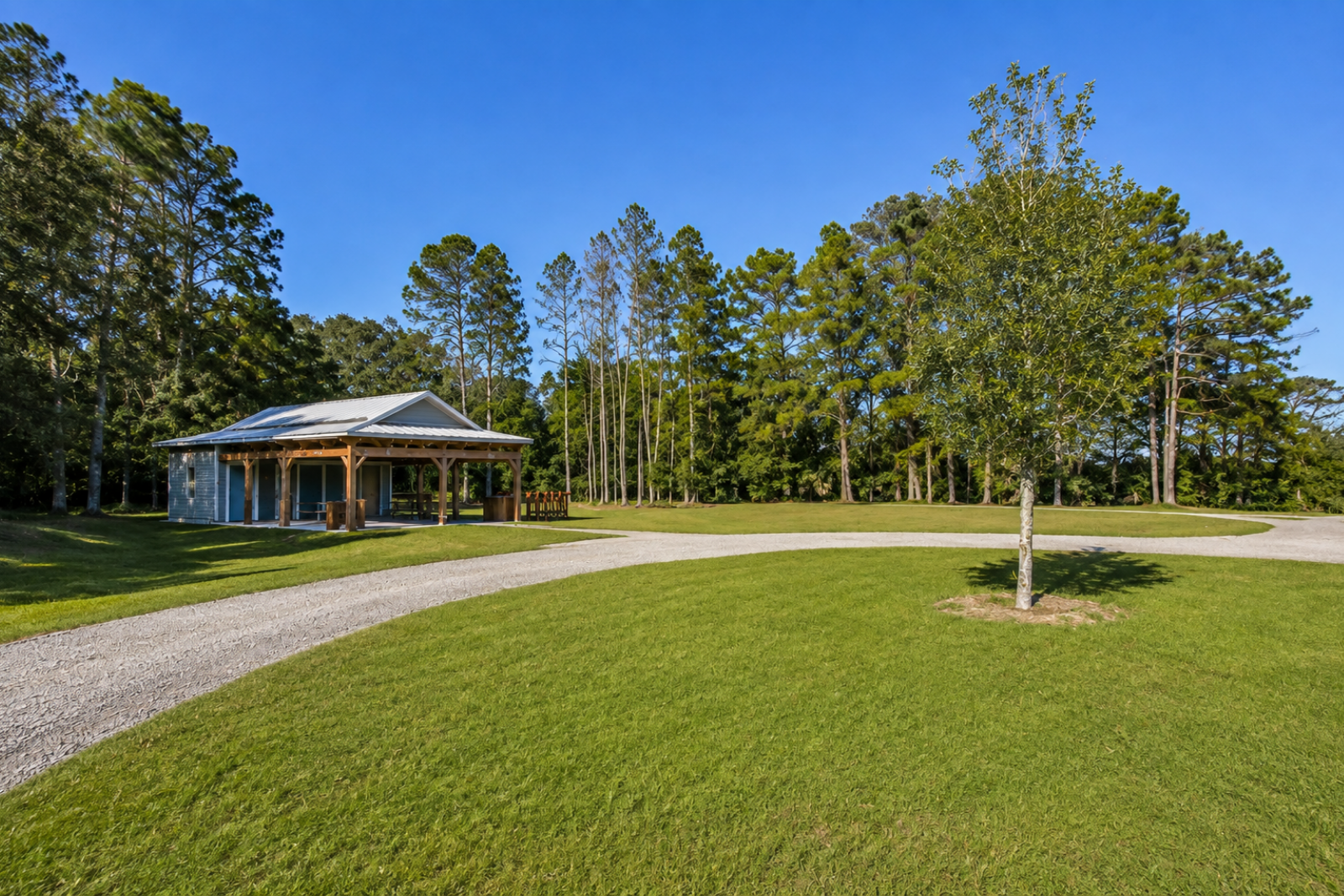 Open-air pavilion and lawn surrounded by trees at Nocatee Landing