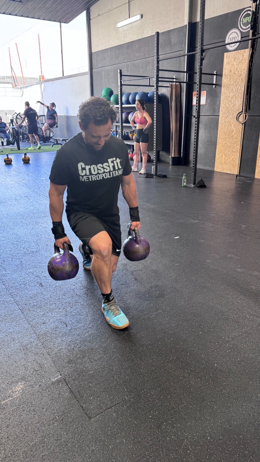 Atleta entrenando con battle ropes en un box de CrossFit
