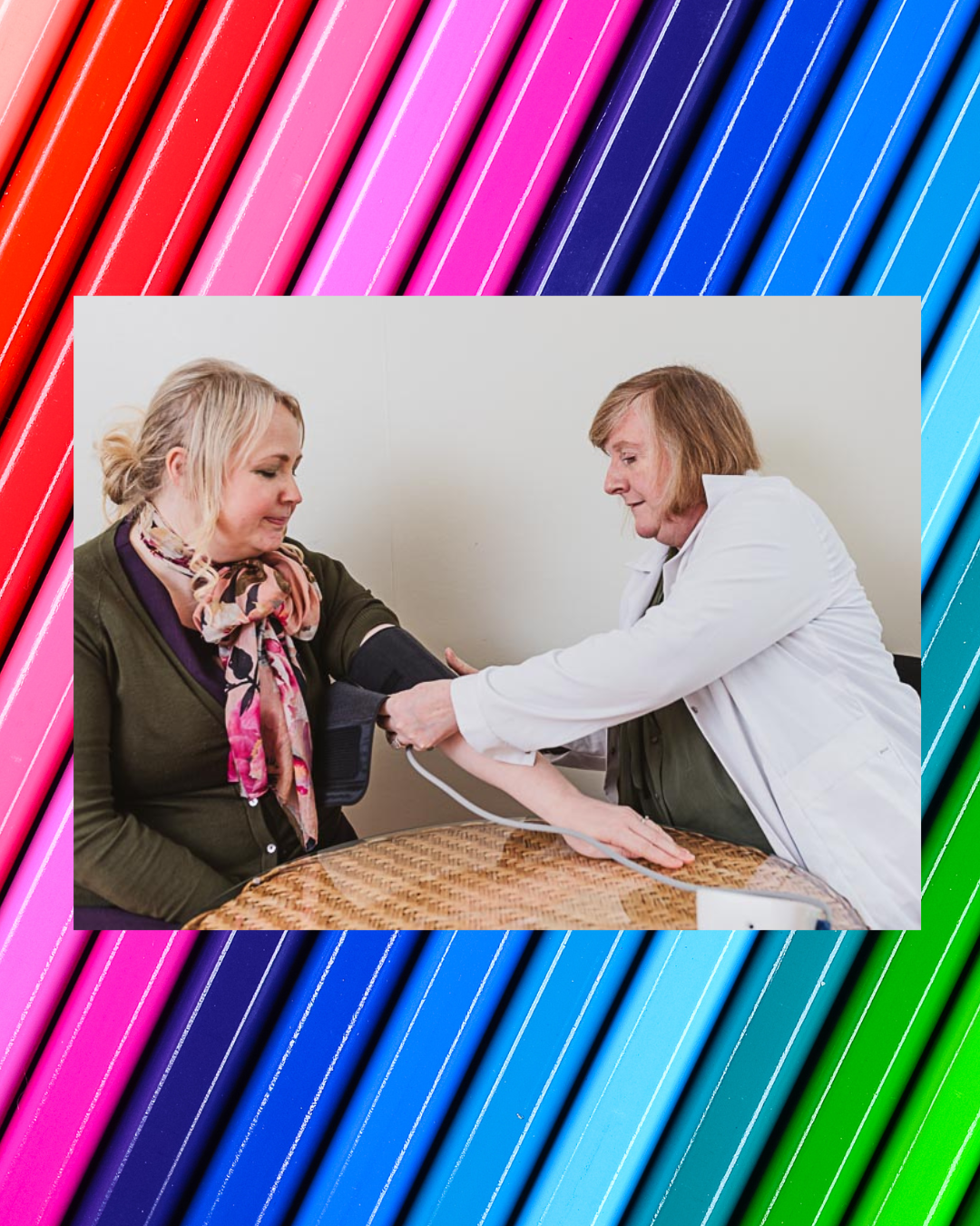 Marie Mulcahy in a white coat taking a patient's blood pressure during a consultation