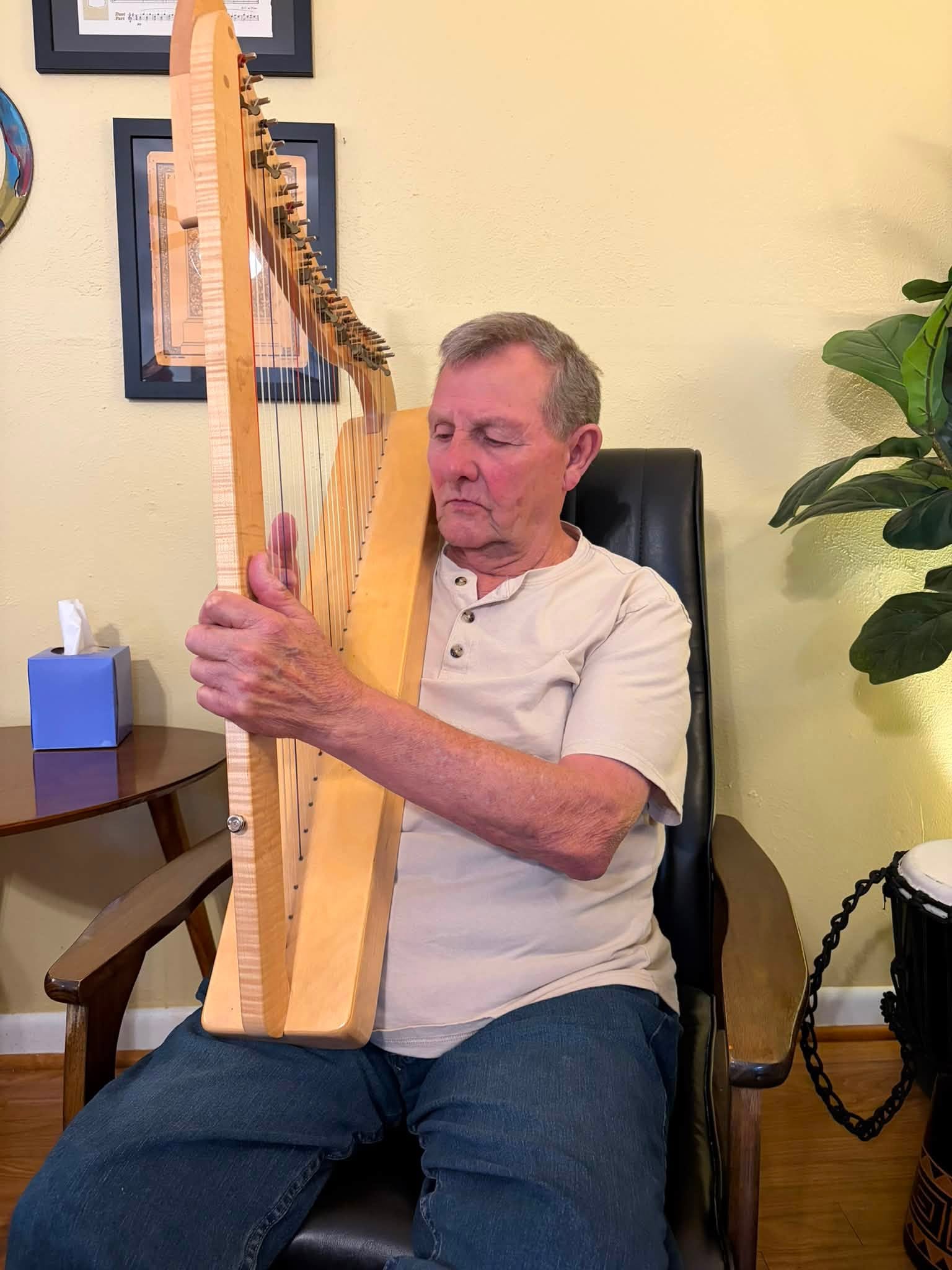 DEC participant exploring music with a harp