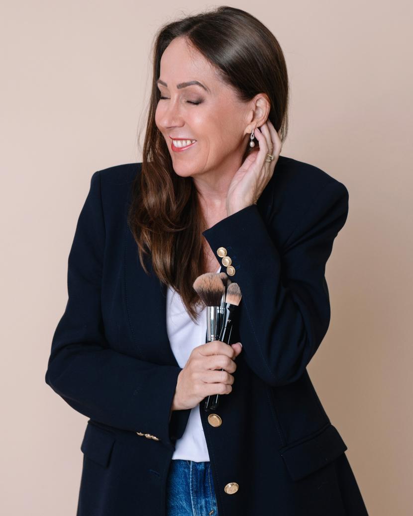 Sue Blackhurst holding makeup brushes, smiling