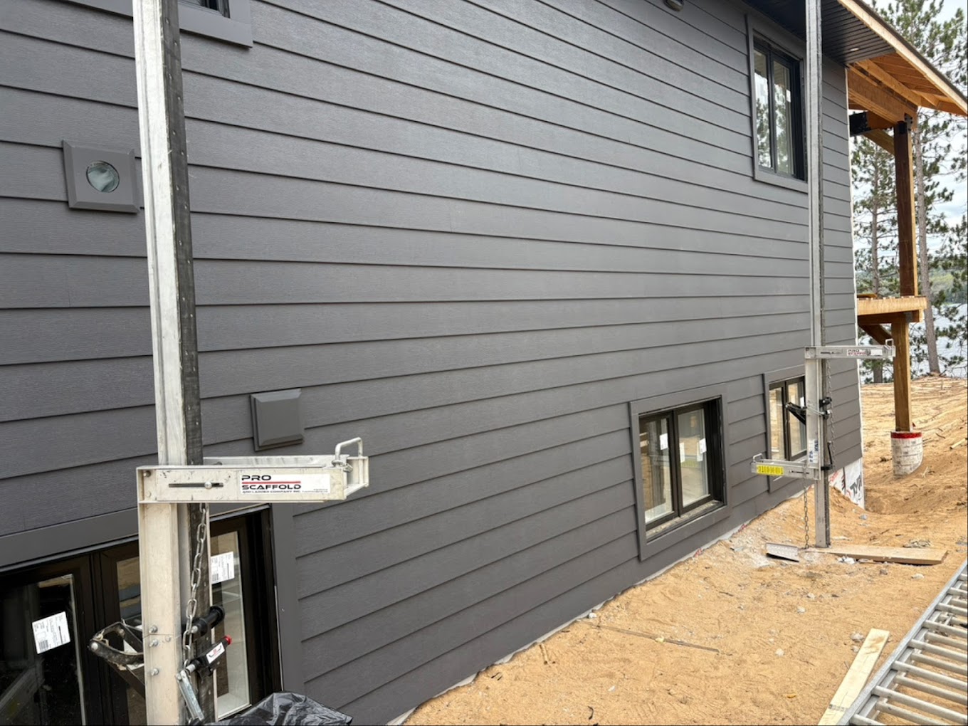 Modern Hamilton-area home with dark grey horizontal siding and black-framed windows