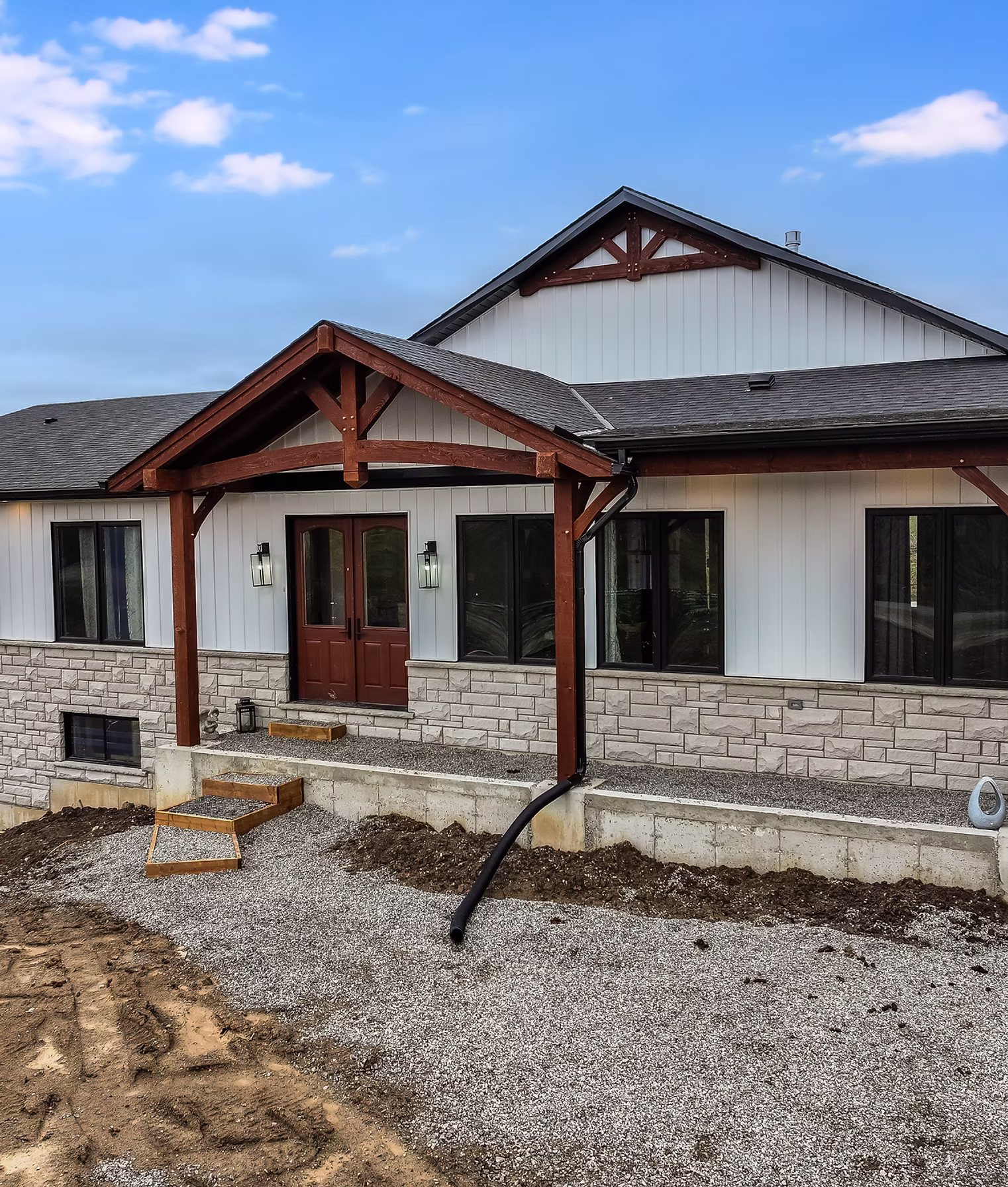 Infinity Gutters crew installing black aluminum gutters on a modern residential home exterior in Hamilton, Ontario