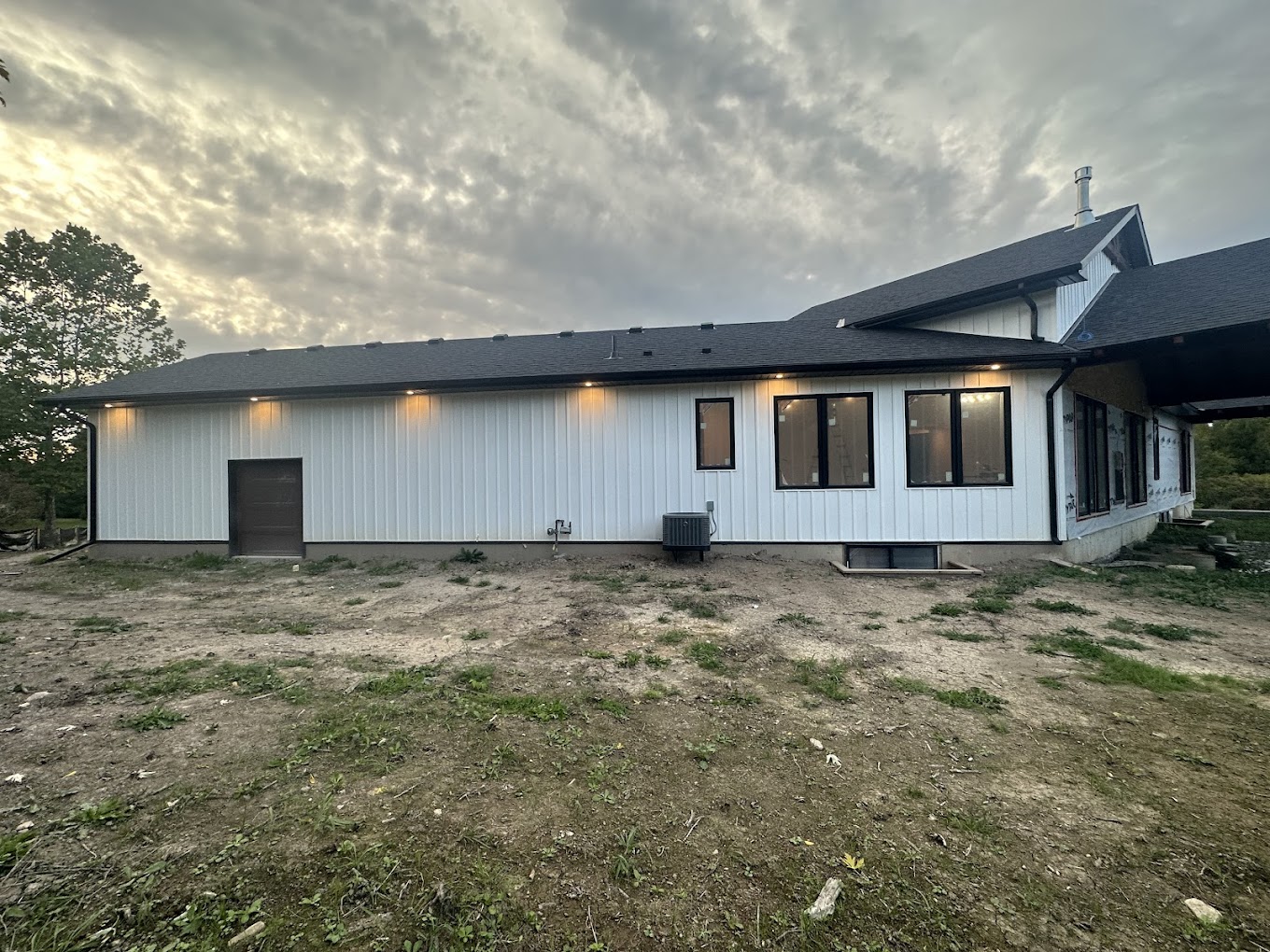 White board-and-batten Hamilton-area home with efficient windows and black exterior details