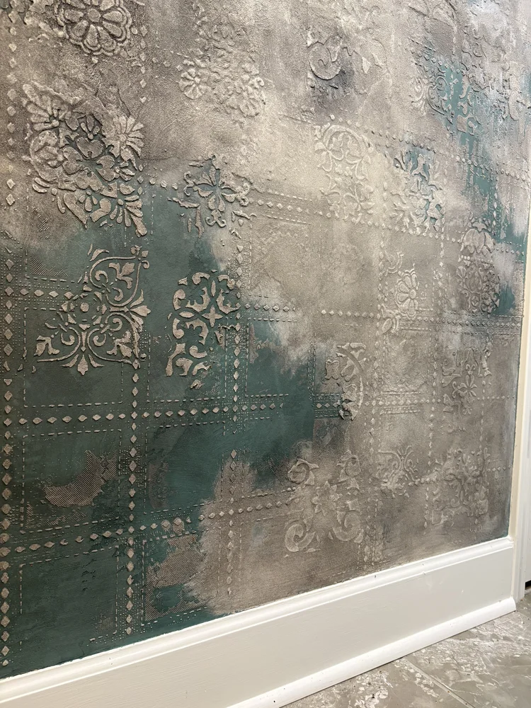 Custom decorative plaster feature wall with layered teal, gray and metallic ornamental detailing