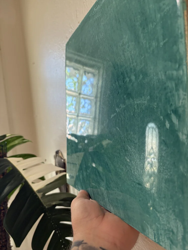 Green polished Venetian plaster sample showcasing rich color, depth and high-gloss reflection