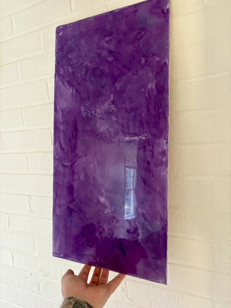 Deep purple Venetian plaster sample with polished movement and reflective handcrafted finish