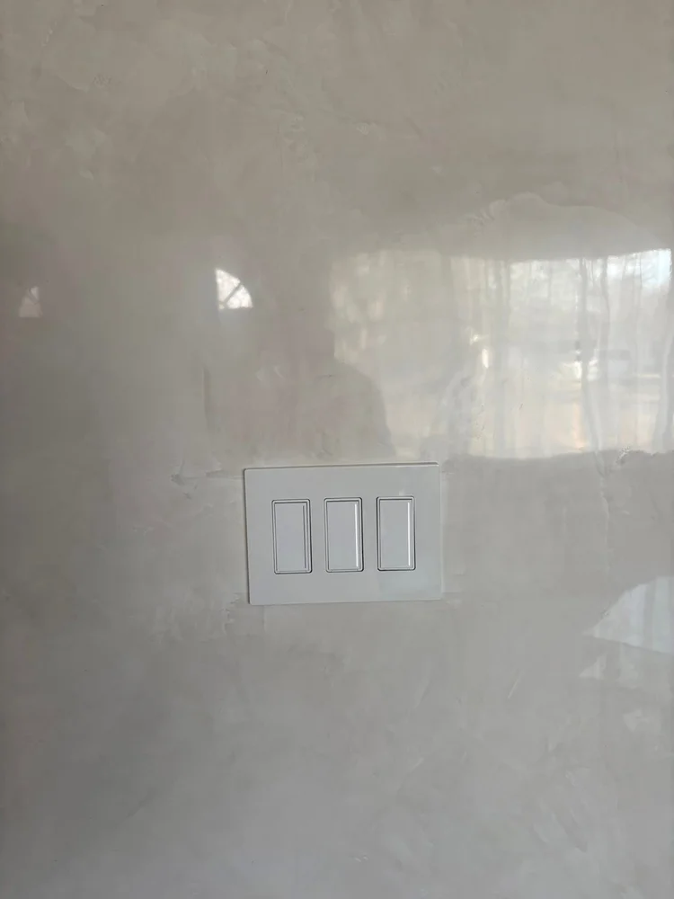 Close-up of polished Venetian plaster showing natural movement, depth and high-gloss reflection
