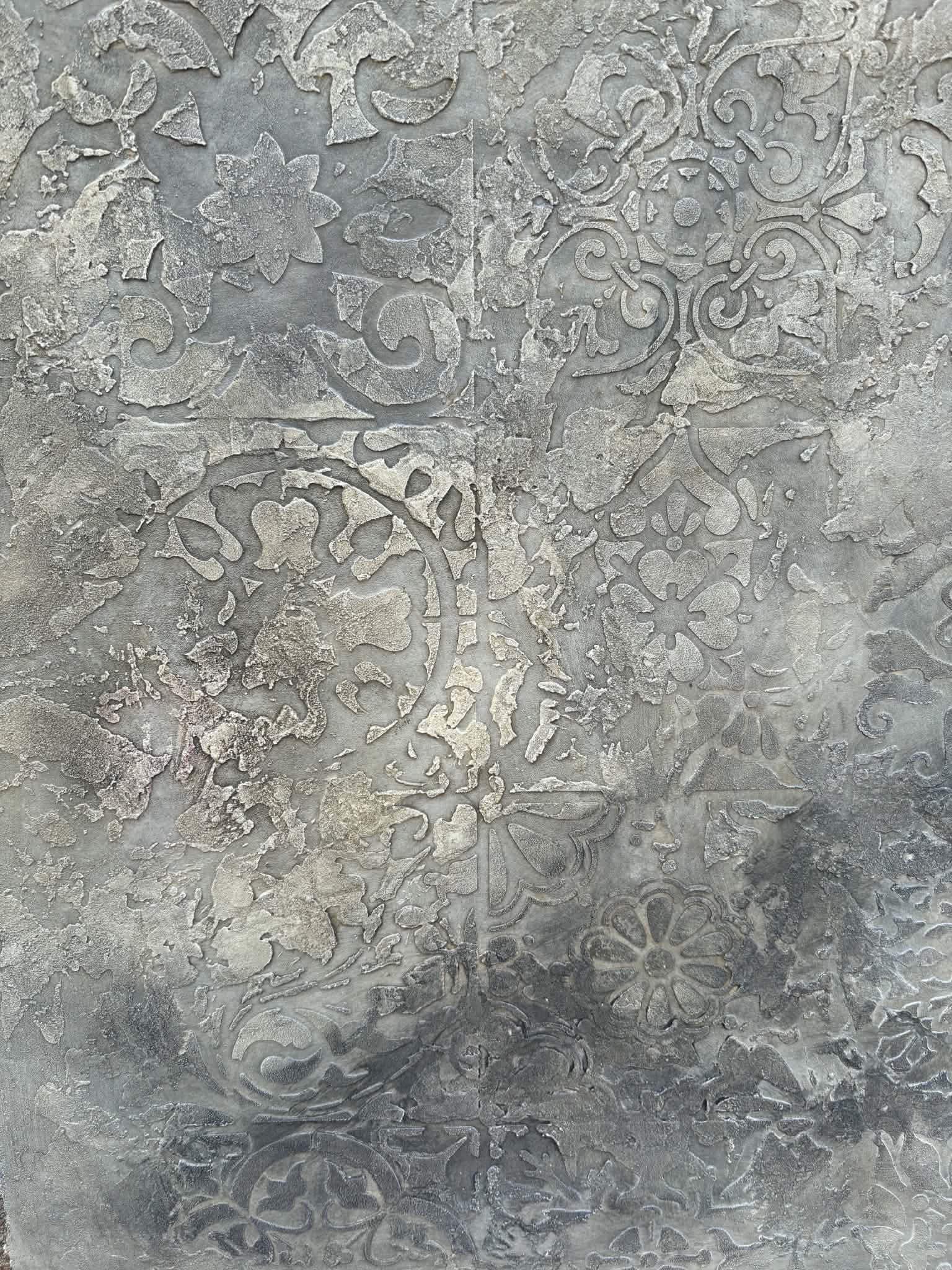 Textured gray decorative plaster finish with layered floral and ornamental detailing