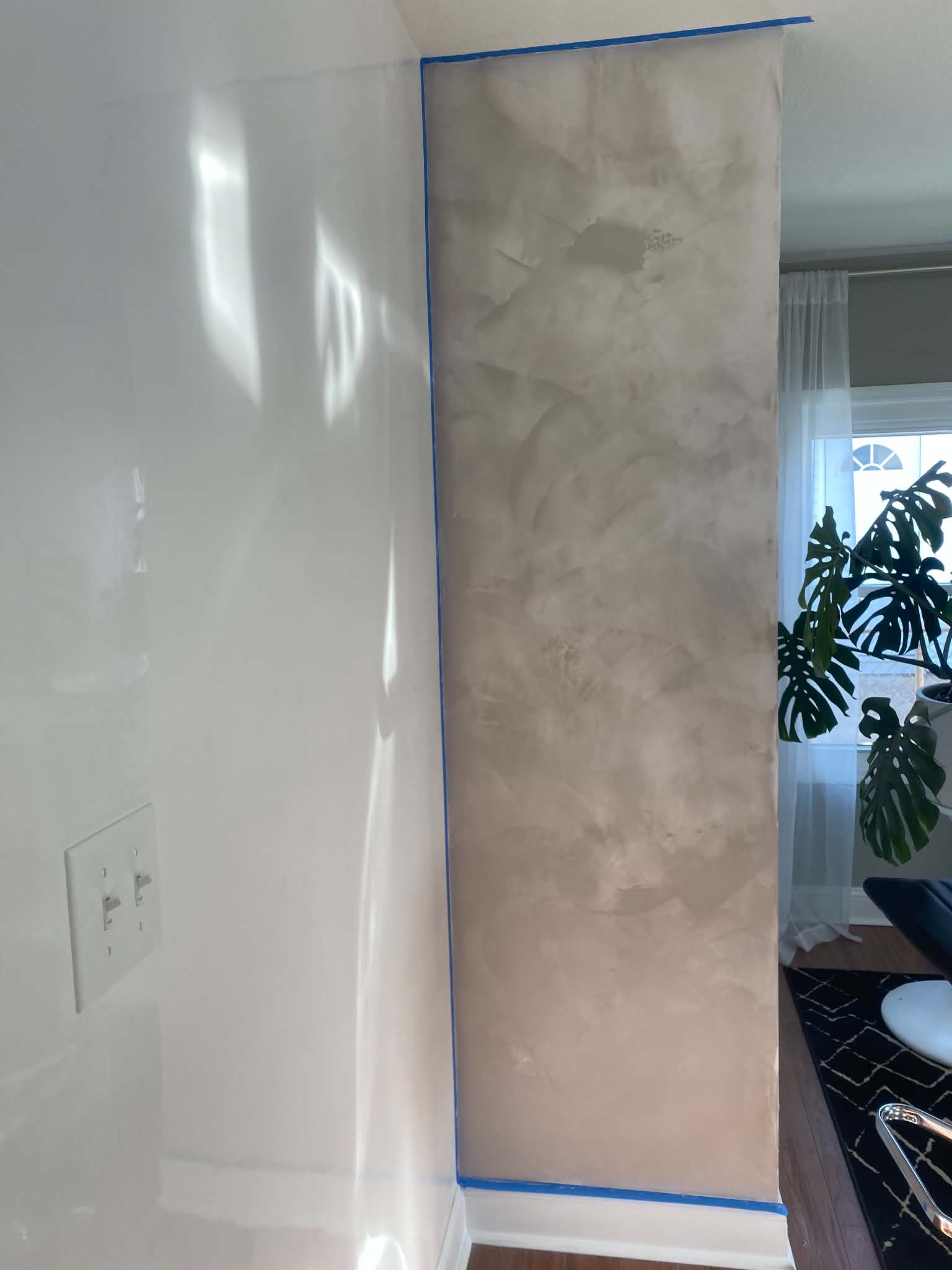 Floor-to-ceiling Venetian plaster accent with soft neutral movement and polished finish