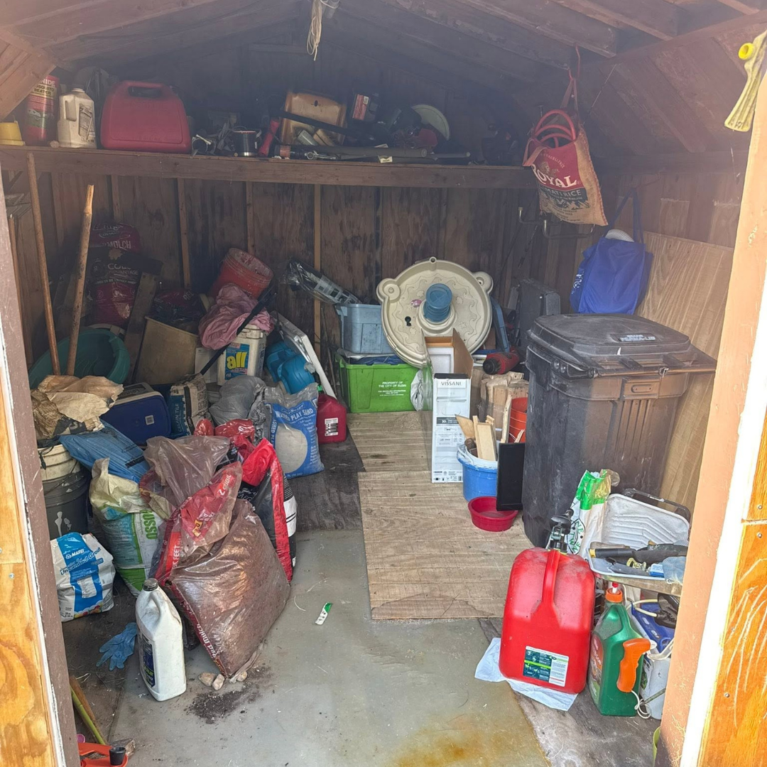 Shed filled with stored equipment and bulky items before cleanout.