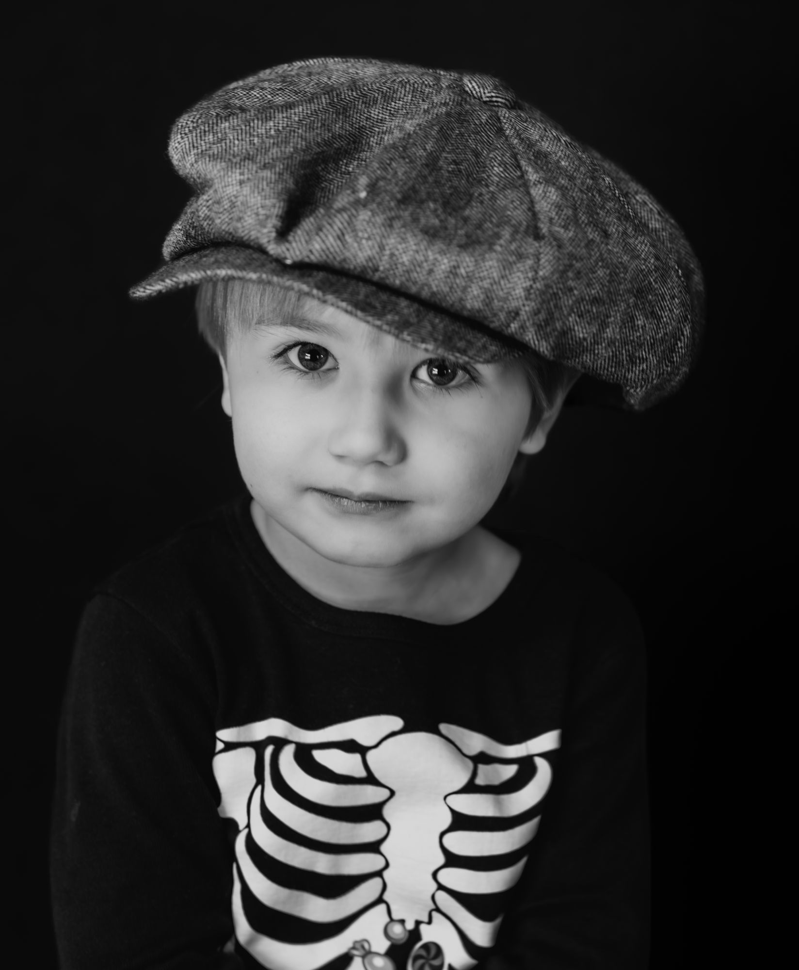 A young boy in a newsboy cap