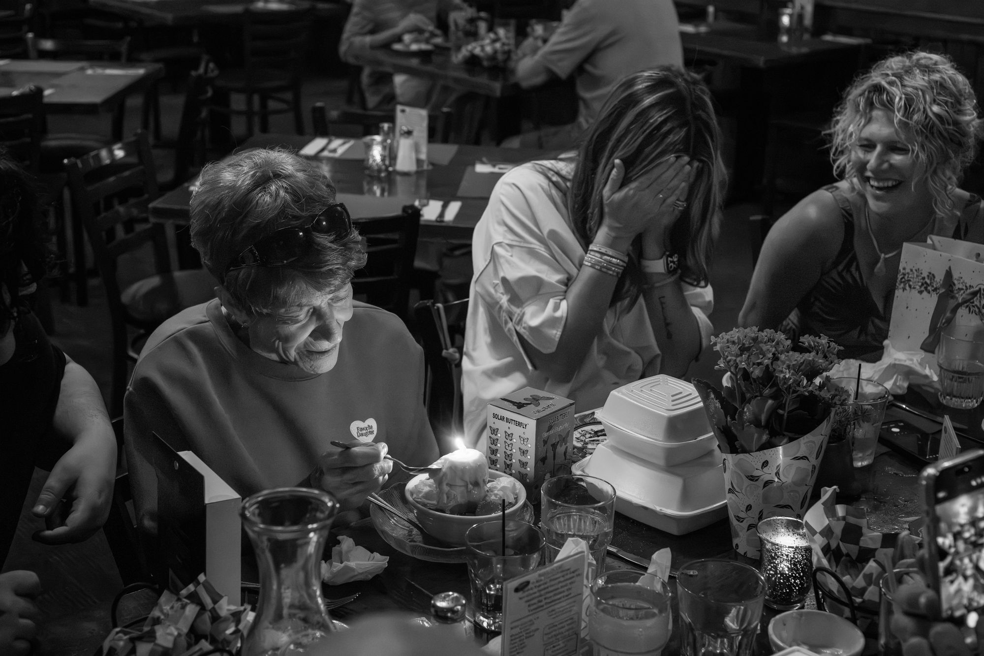 A birthday table with an older woman at a cake
