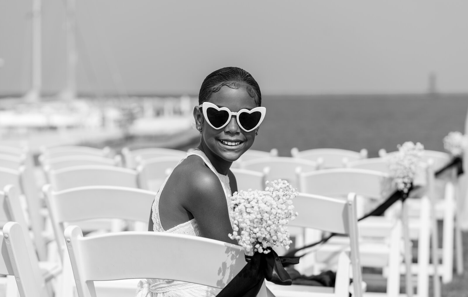 A flower girl in heart sunglasses at a celebration