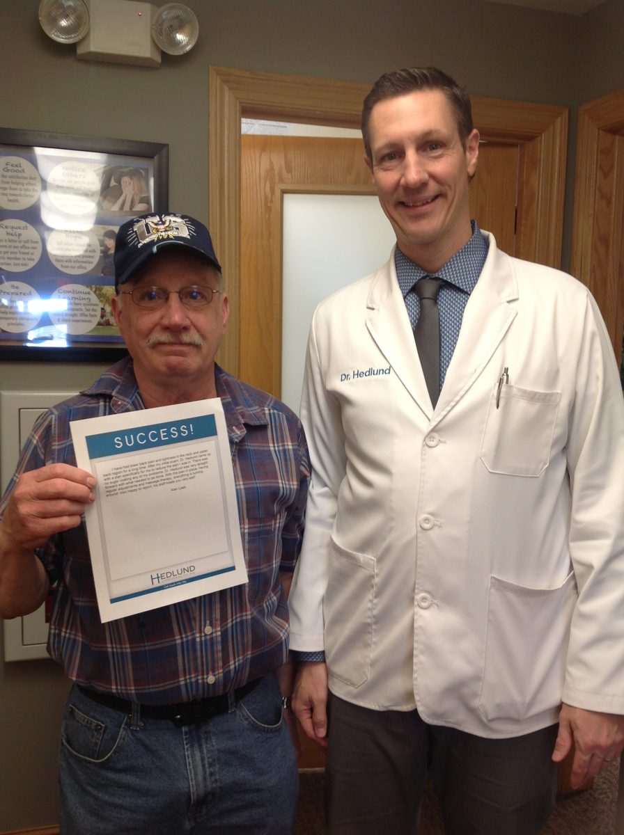 Alan L. with Dr. Bryan Hedlund, holding his success story