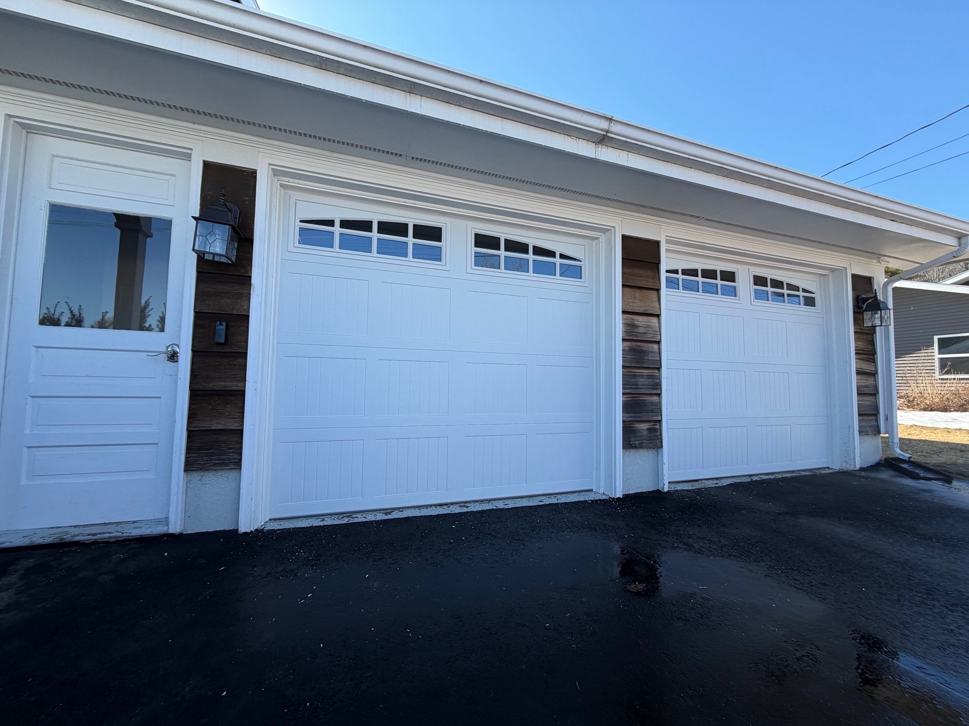 Double garage door replacement — white with arched window panels