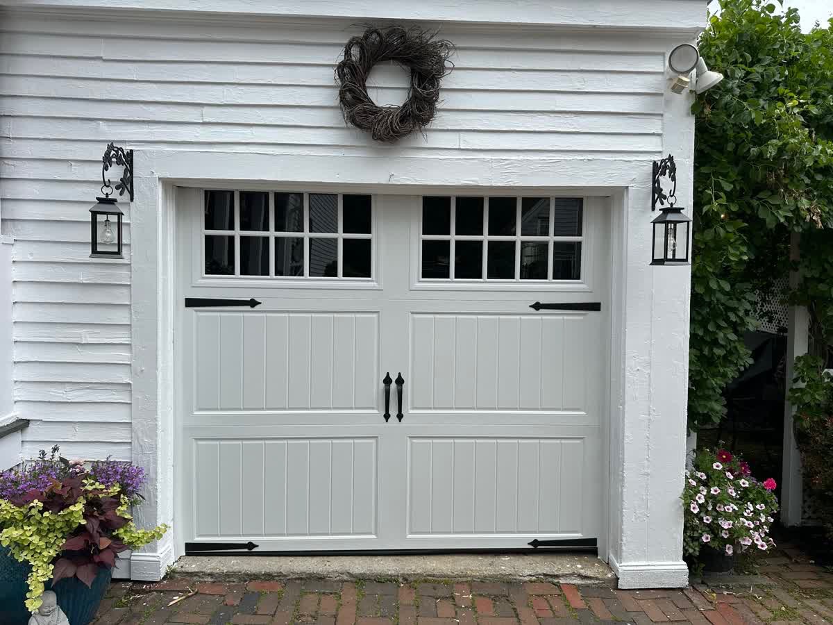 White carriage door installation — black hardware and coach lights