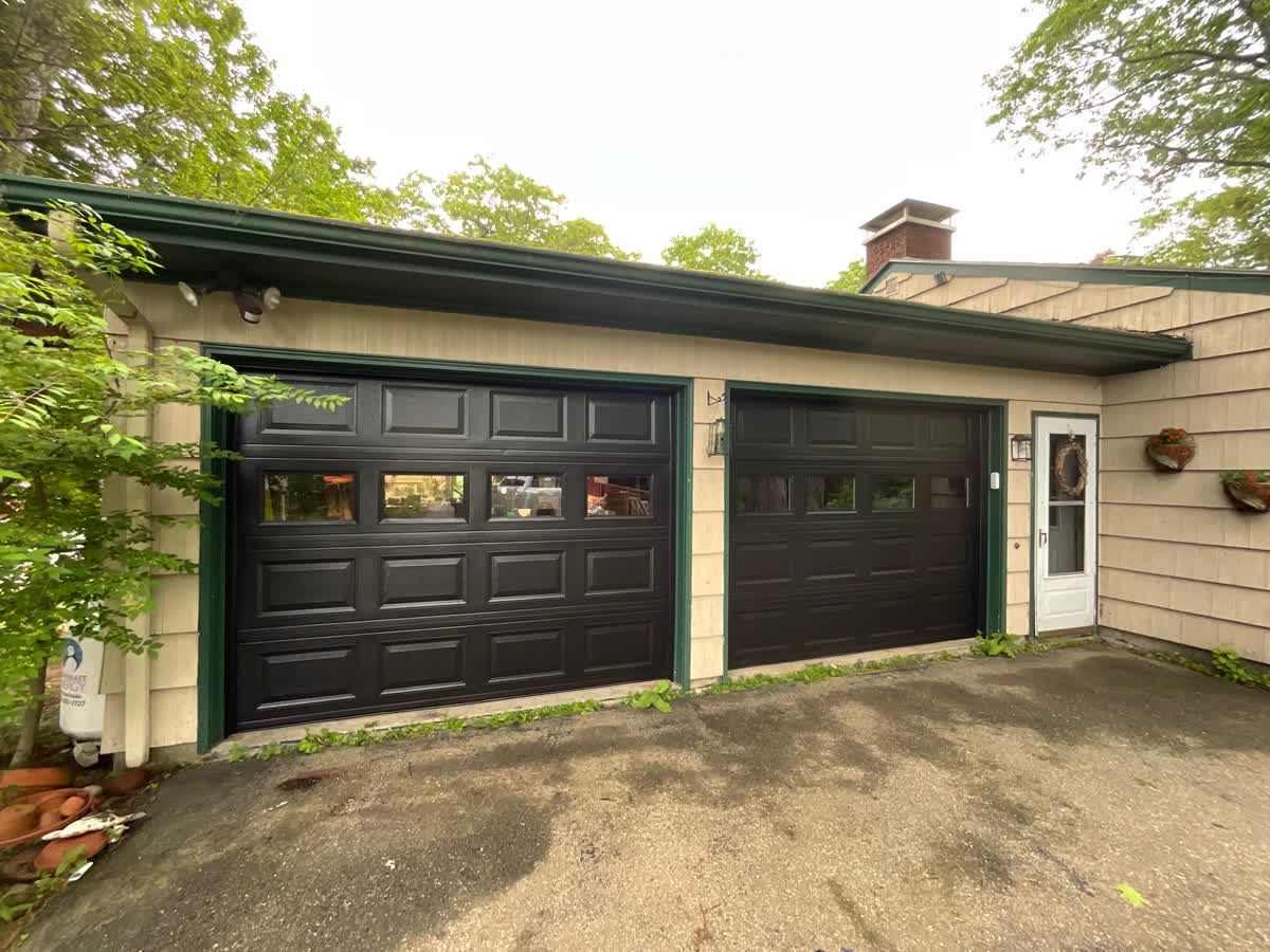 Two-car garage door replacement — dark finish with glass panels