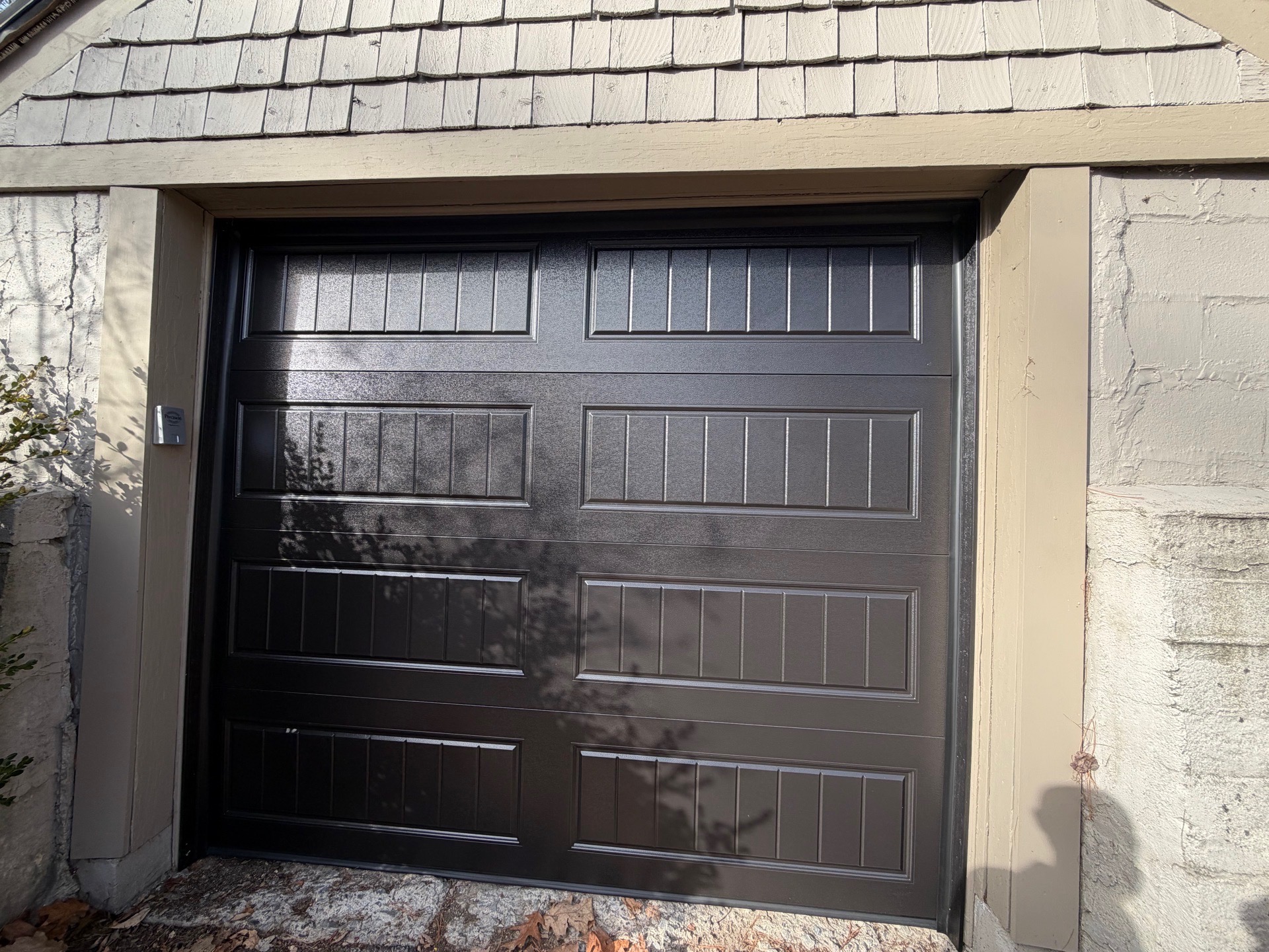 Single door installation — dark charcoal finish, stone surround