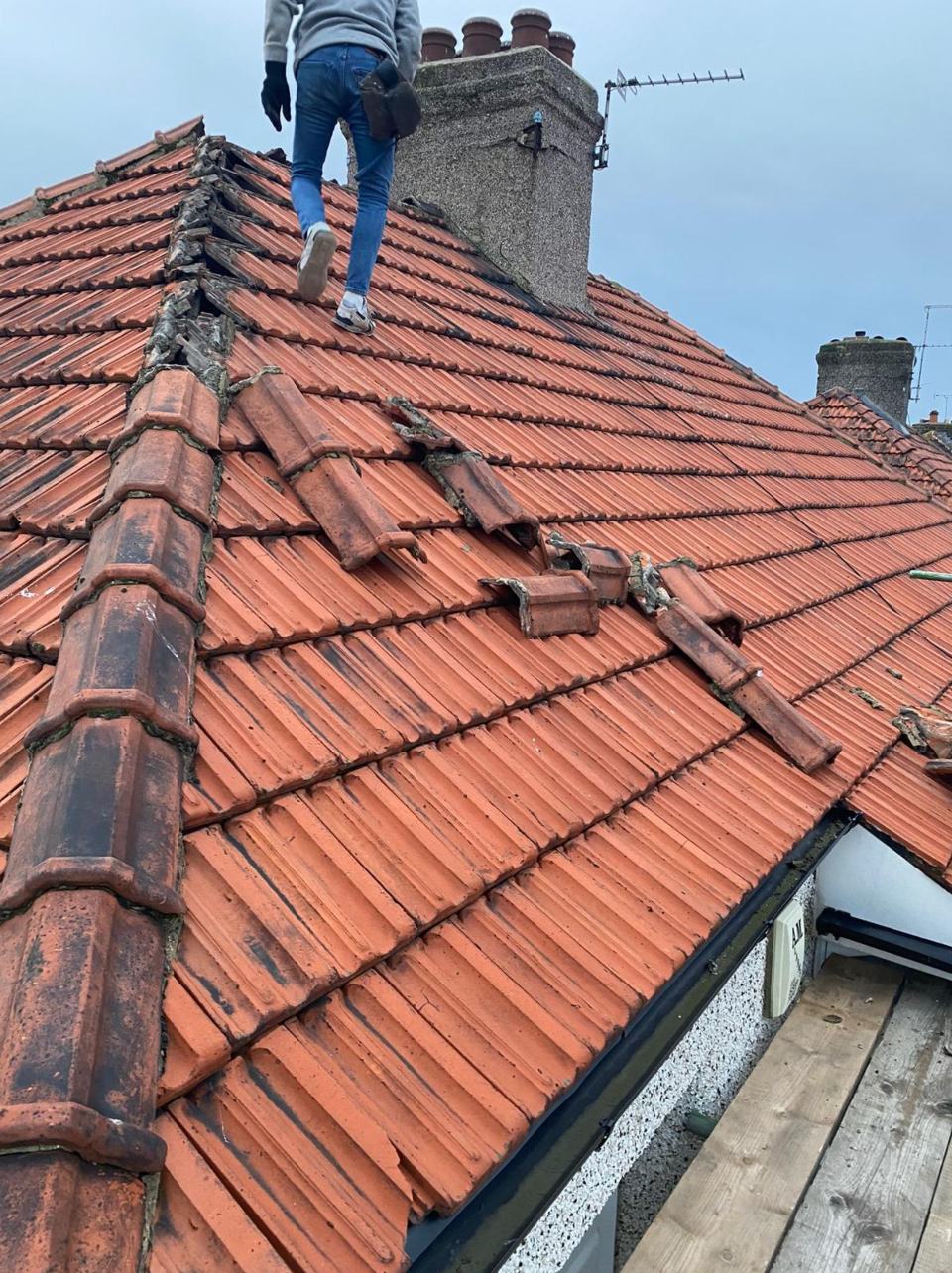 Old tiles being stripped from a roof