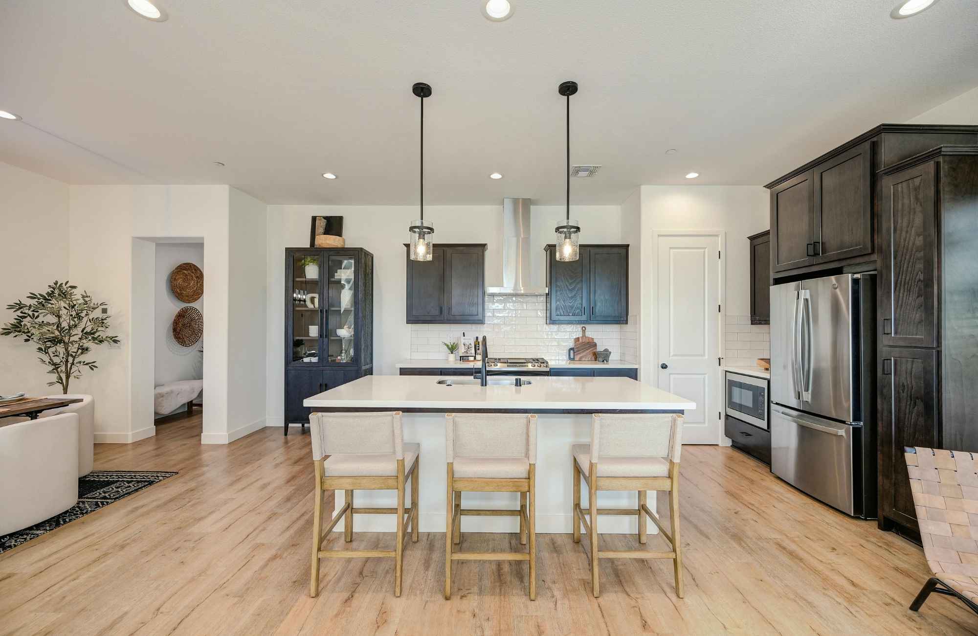 professional-home-organizer-sedona-az-making-moving-easier-kitchen-with-island-dark-and-light-cabinets-wood-floors-open-to-living-room