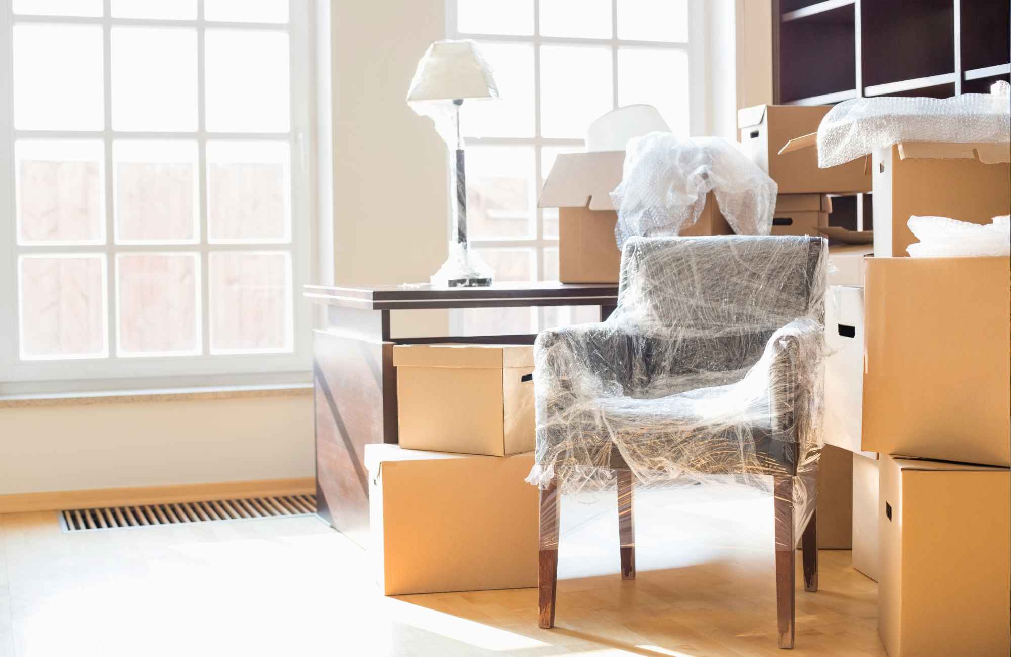 shannon's-organizing-solutions-kingman-az-making-moving-easier-room-with-stacks-of-moving-boxes-wrapped-chair-elevated-move-management