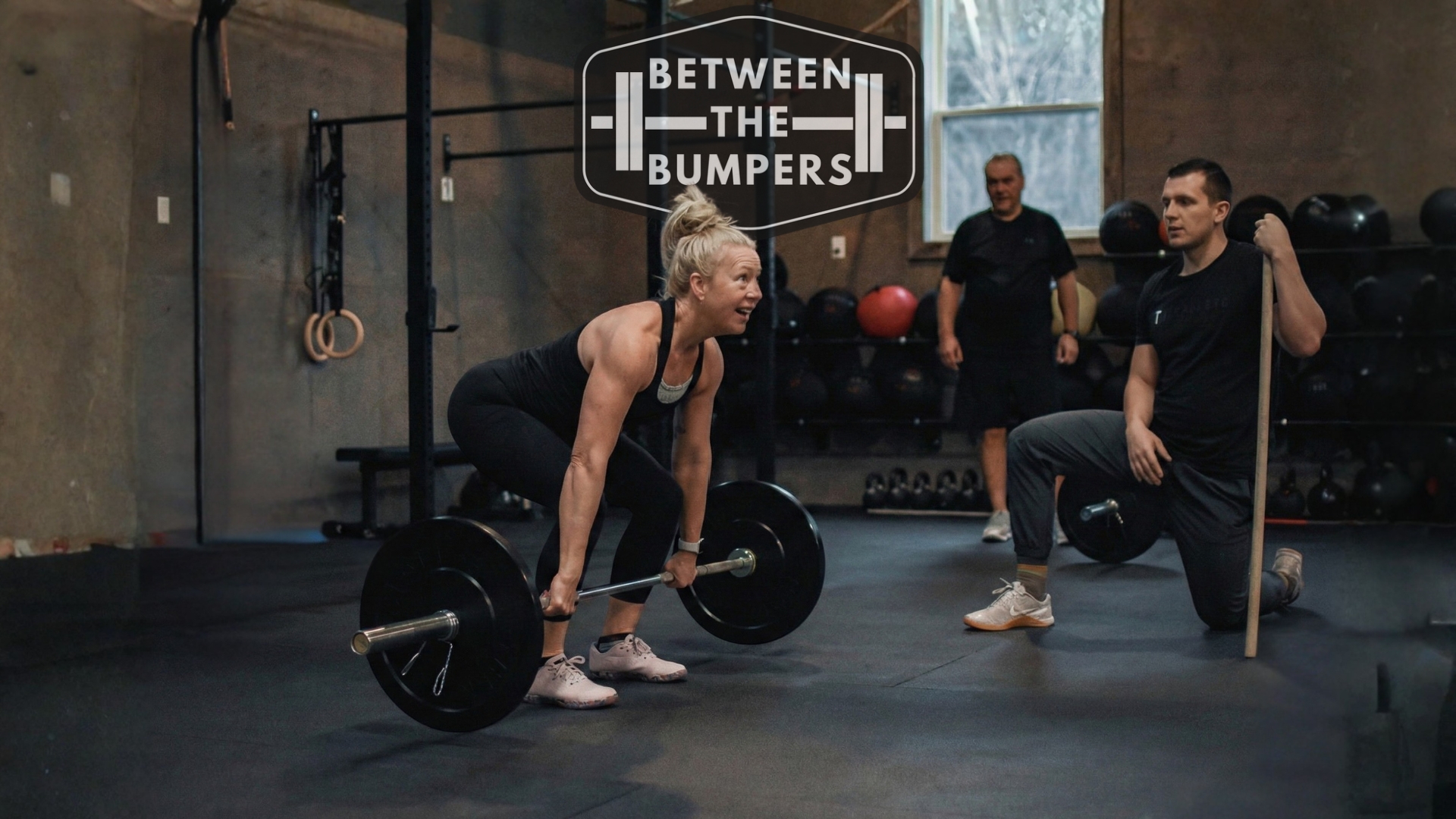 Coach Sam guiding a client through a deadlift at Between The Bumpers