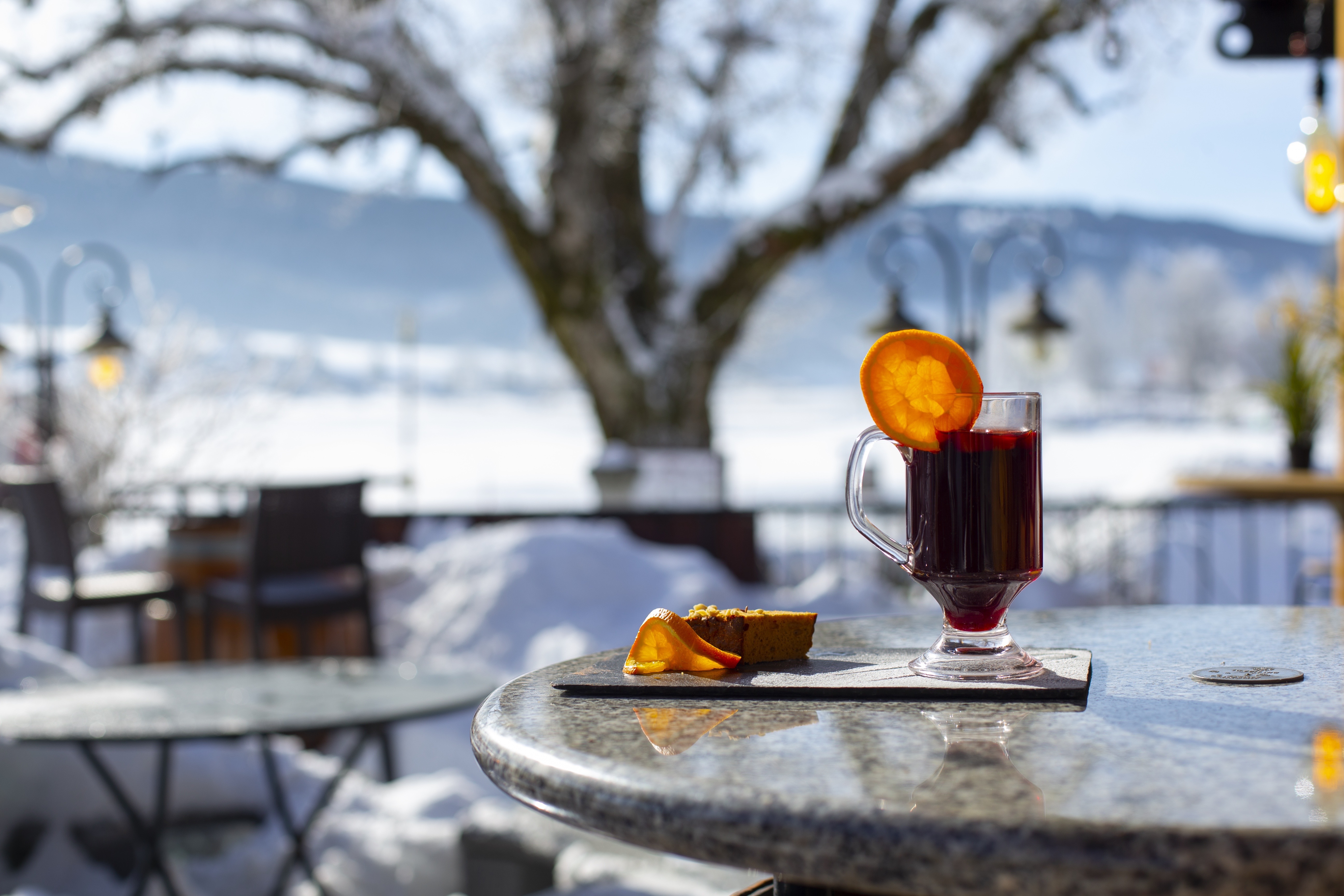 Café ou boisson chaude servie en terrasse face au Lac de Joux en hiver