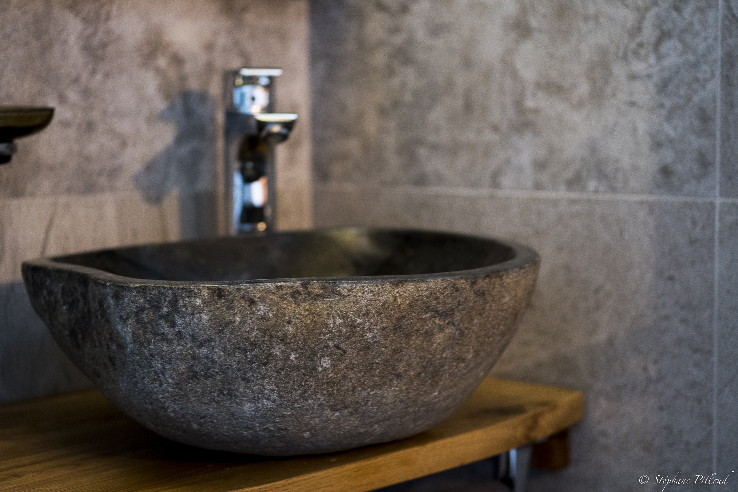 Salle de bain avec vasque en pierre dans une chambre de l’hôtel
