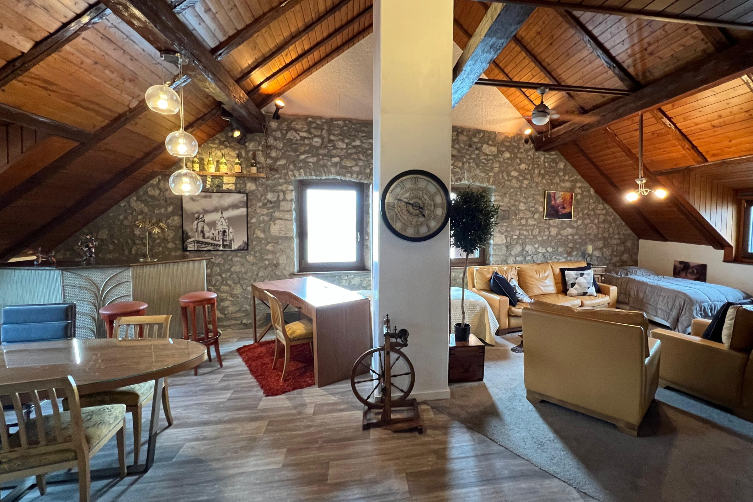 Loft spacieux et chaleureux de l’Hôtel de la Truite avec salon ouvert et poutres apparentes