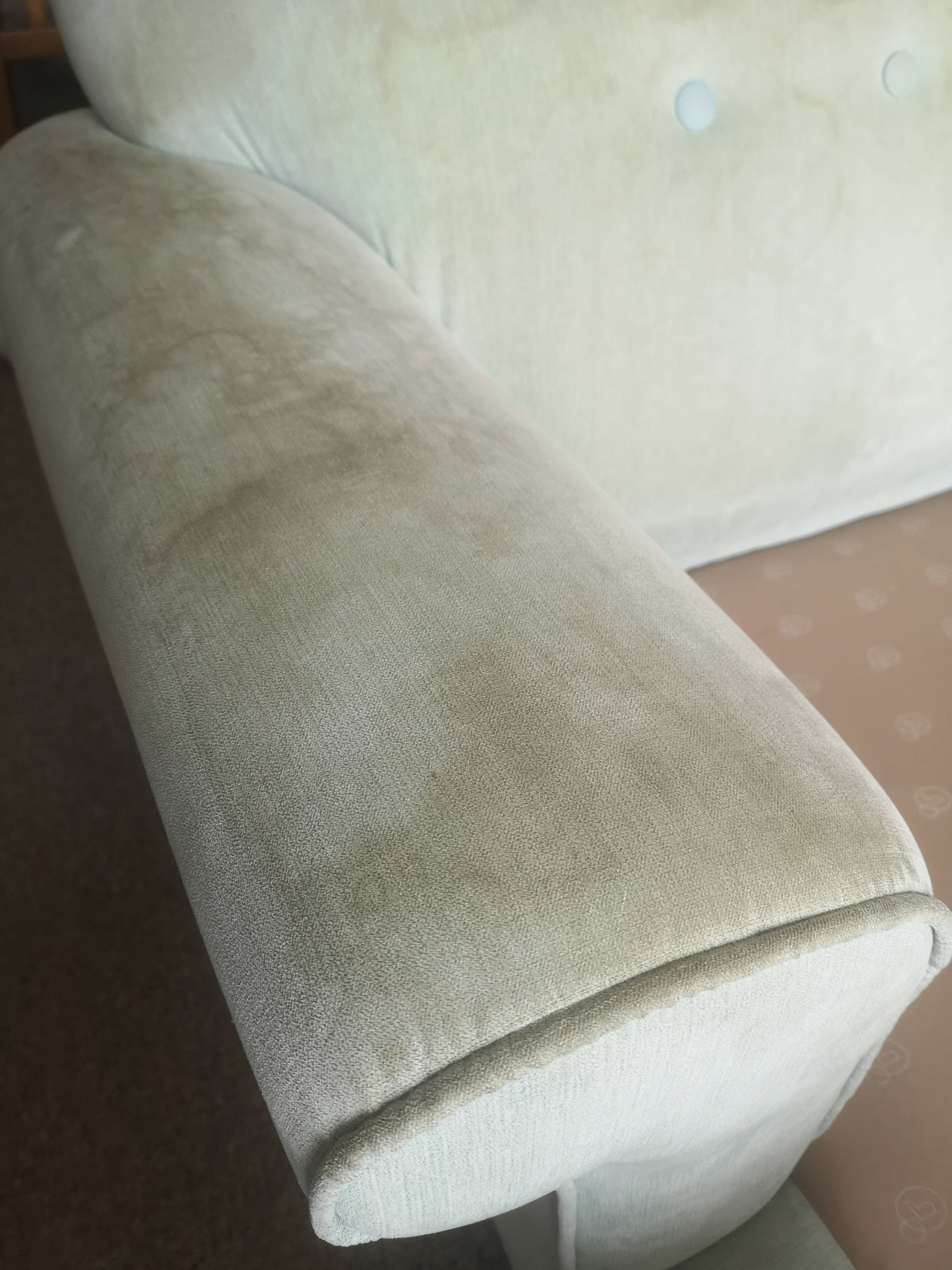 Grey fabric sofa before professional cleaning - showing stains and dirt on armrest