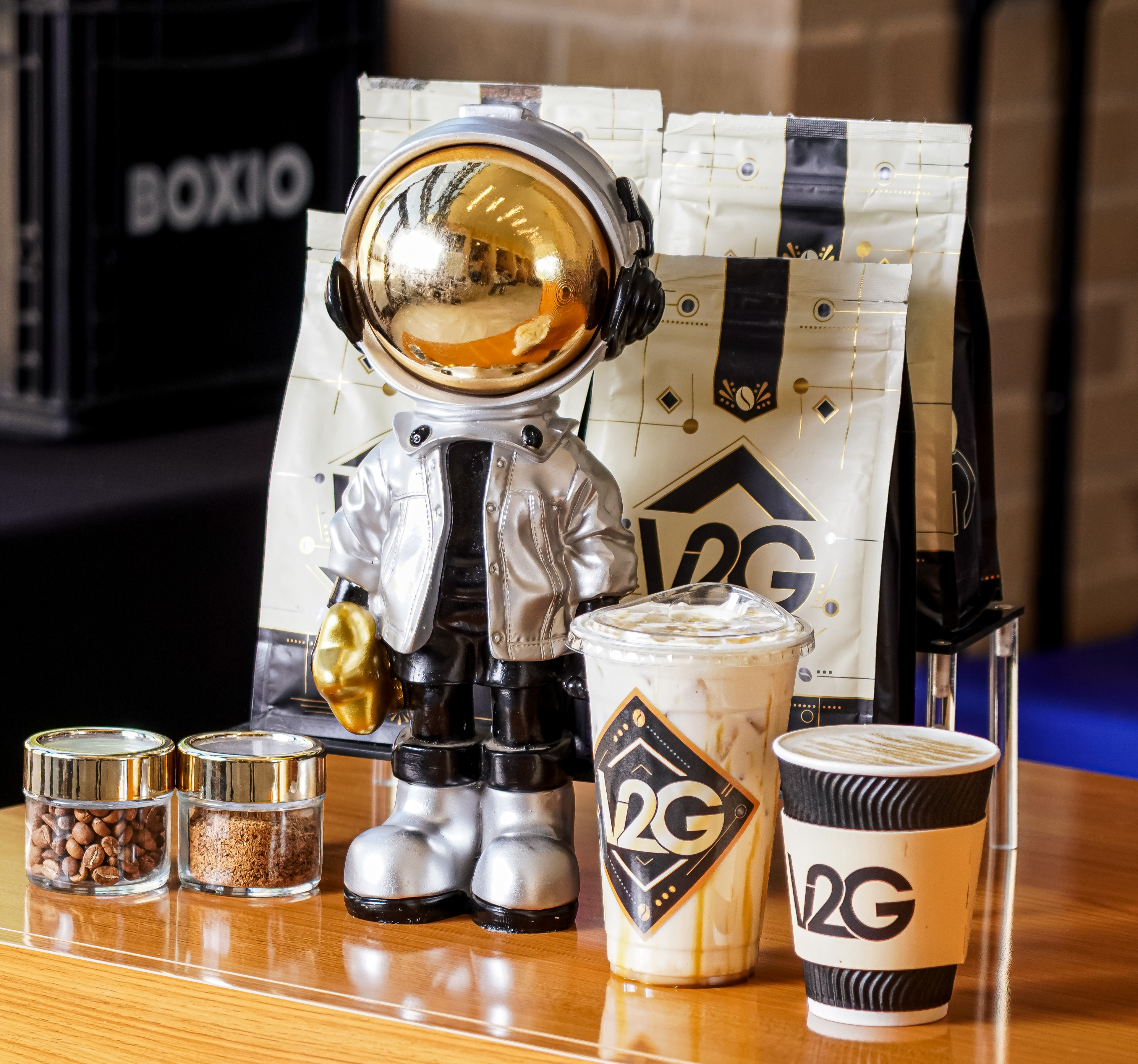 White coffee from Vibes 2 Go served in a branded cup on a table with books and coffee beans inside Midland Community Theatre