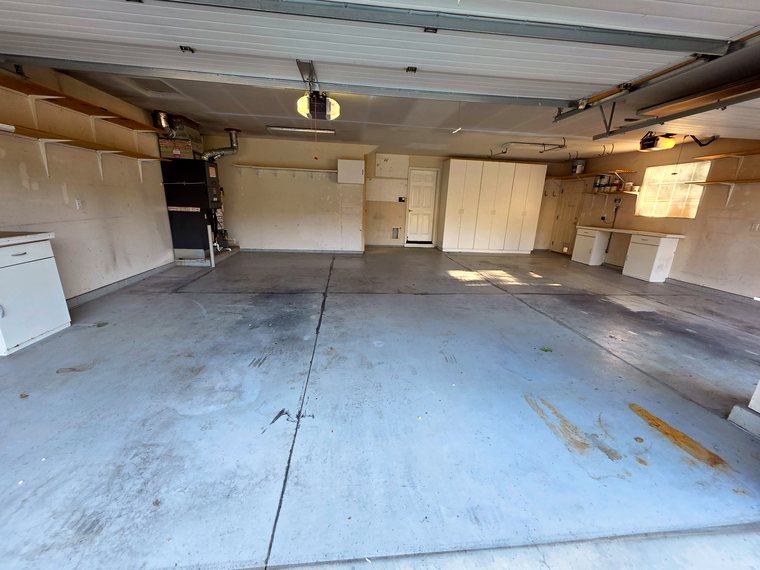Badly stained bare concrete garage floor before coating