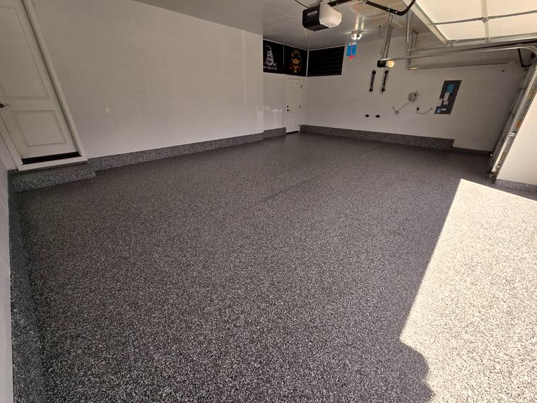 The same garage after a dark flake coating with matching baseboard