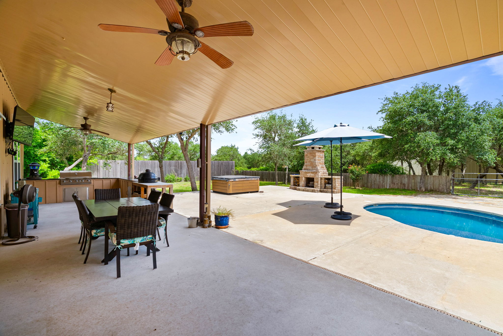Backyard pool beside a barndominium home with large shop in the background