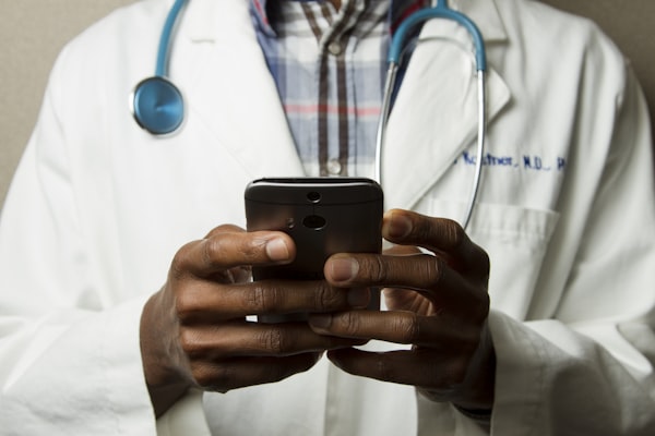 Ärztin mit Smartphone – BGM-Prozess und betriebliche Gesundheitsversorgung