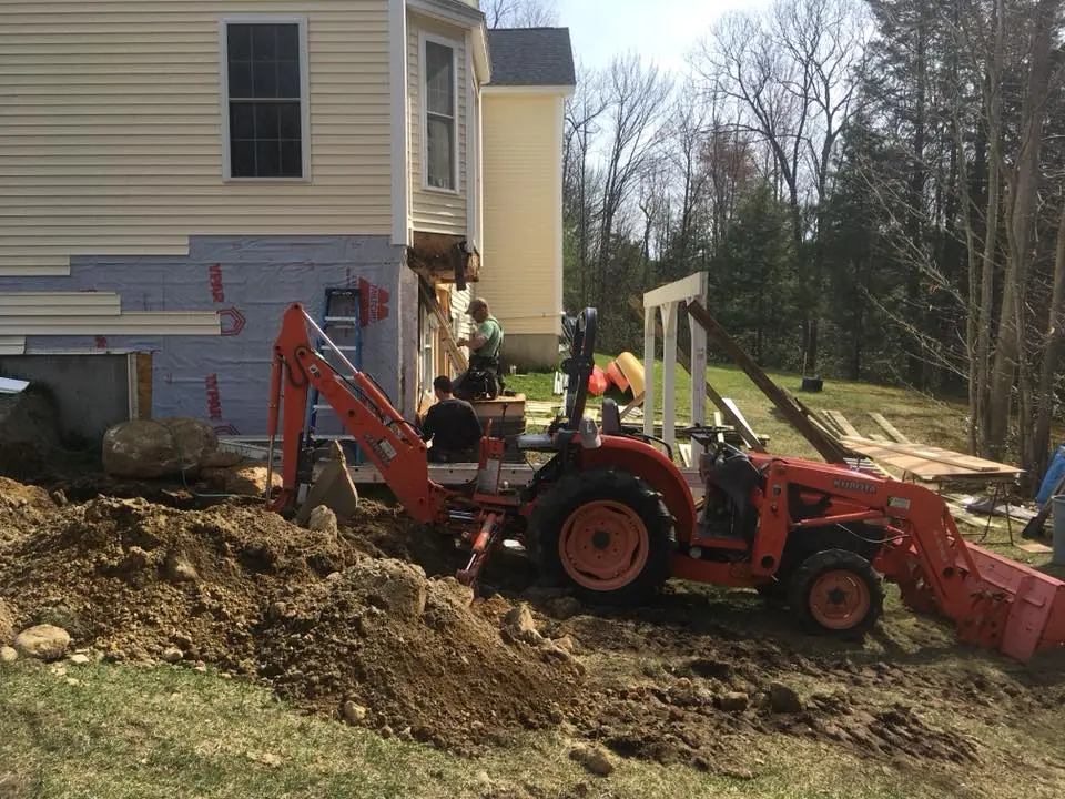 Deck construction site preparation beside a home.