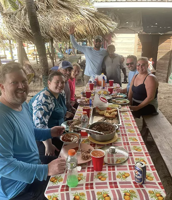 a group of people enjoying a meal in the caribbean