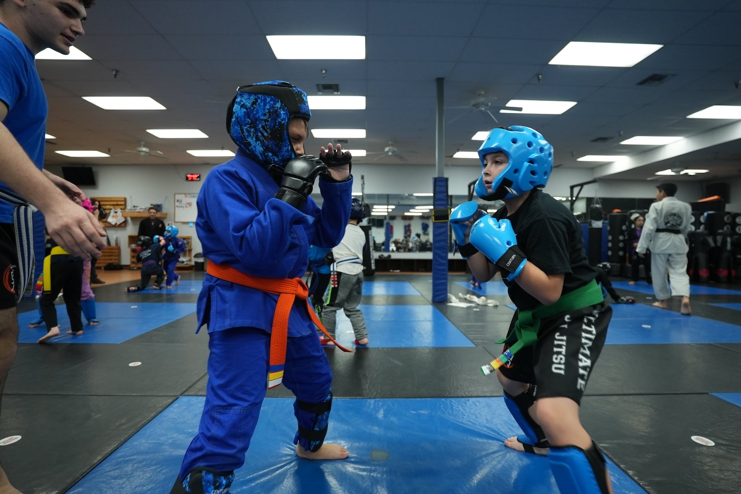 Teen MMA class in Fresno at Ultimate Martial Arts, students in headgear and gloves training striking