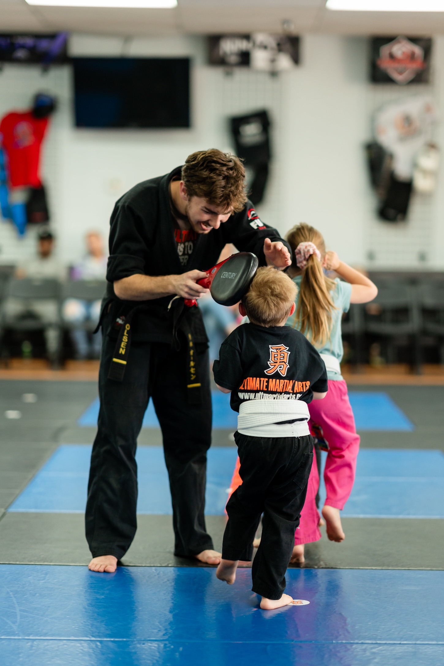 Lil Ninjas kids martial arts class in Fresno, instructor holding a pad for young students at Ultimate Martial Arts