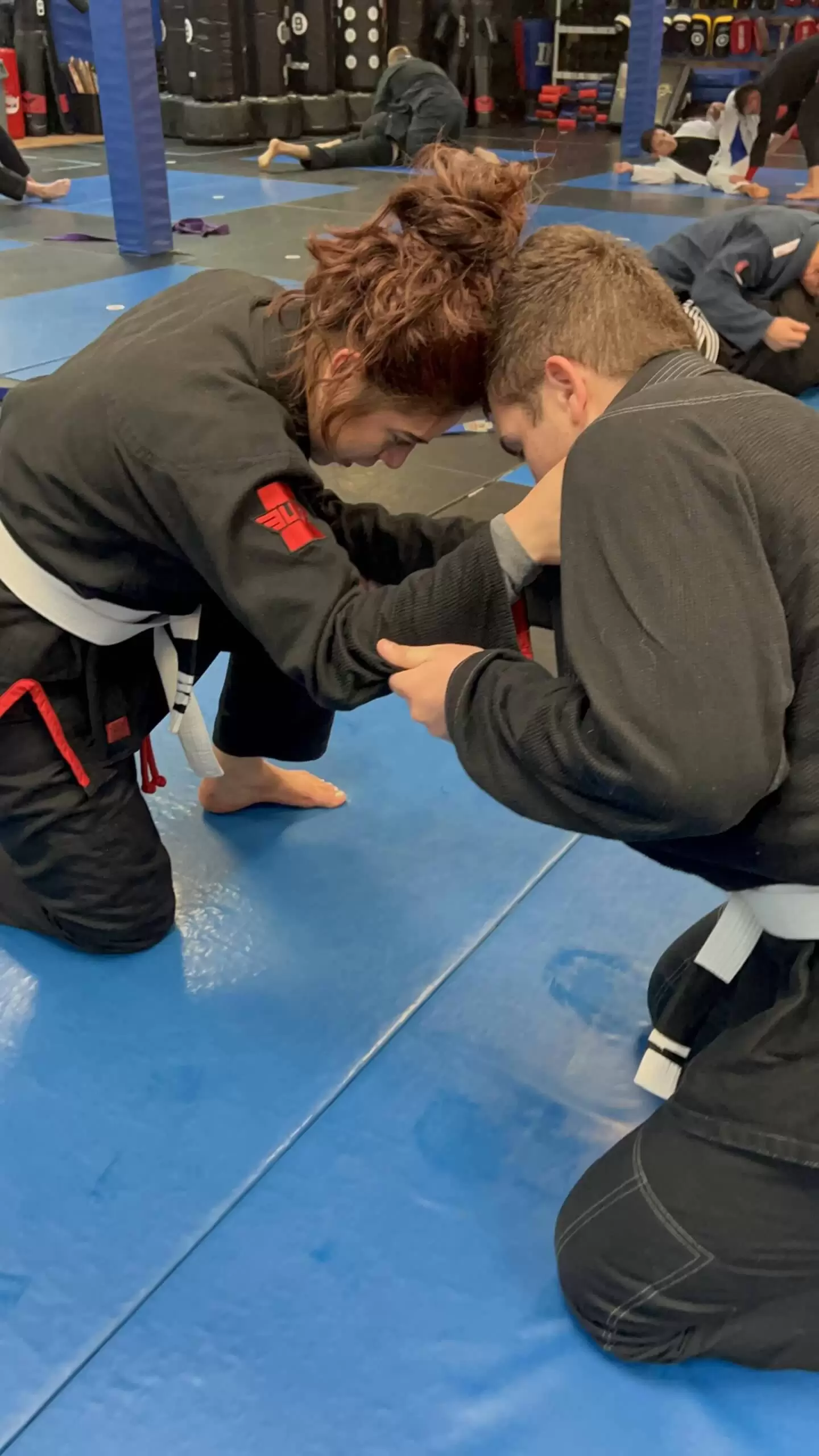 Adult Brazilian Jiu Jitsu class in Fresno at Ultimate Martial Arts, two students drilling grappling on the mats