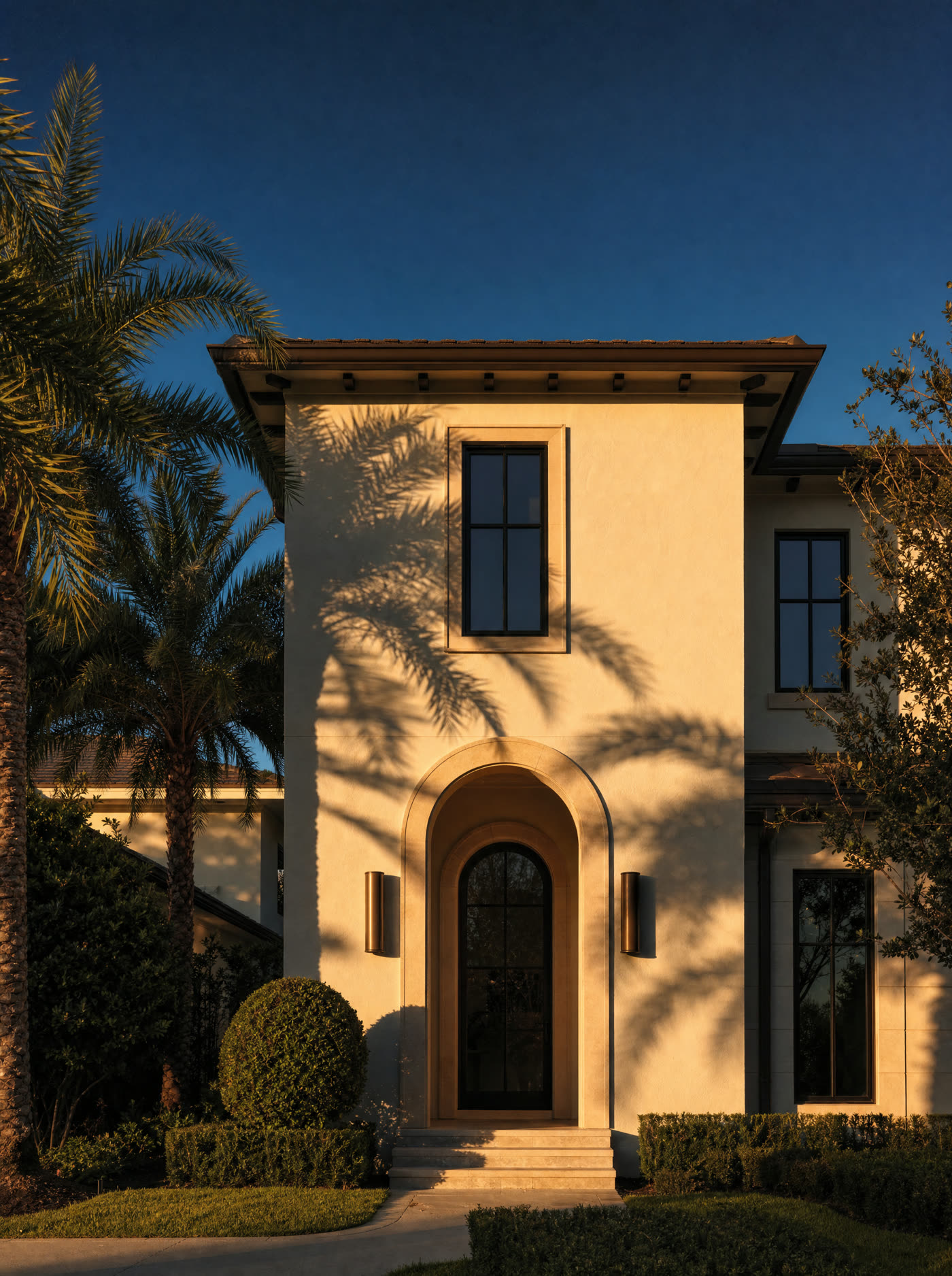 Arched limestone entryway of a Central Florida home in late afternoon light