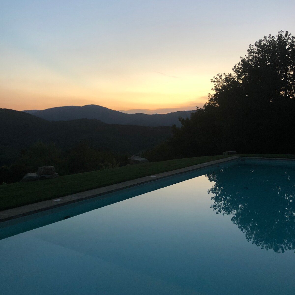 Villa Pregiata swimming pool at sunset, overlooking wooded Italian hills