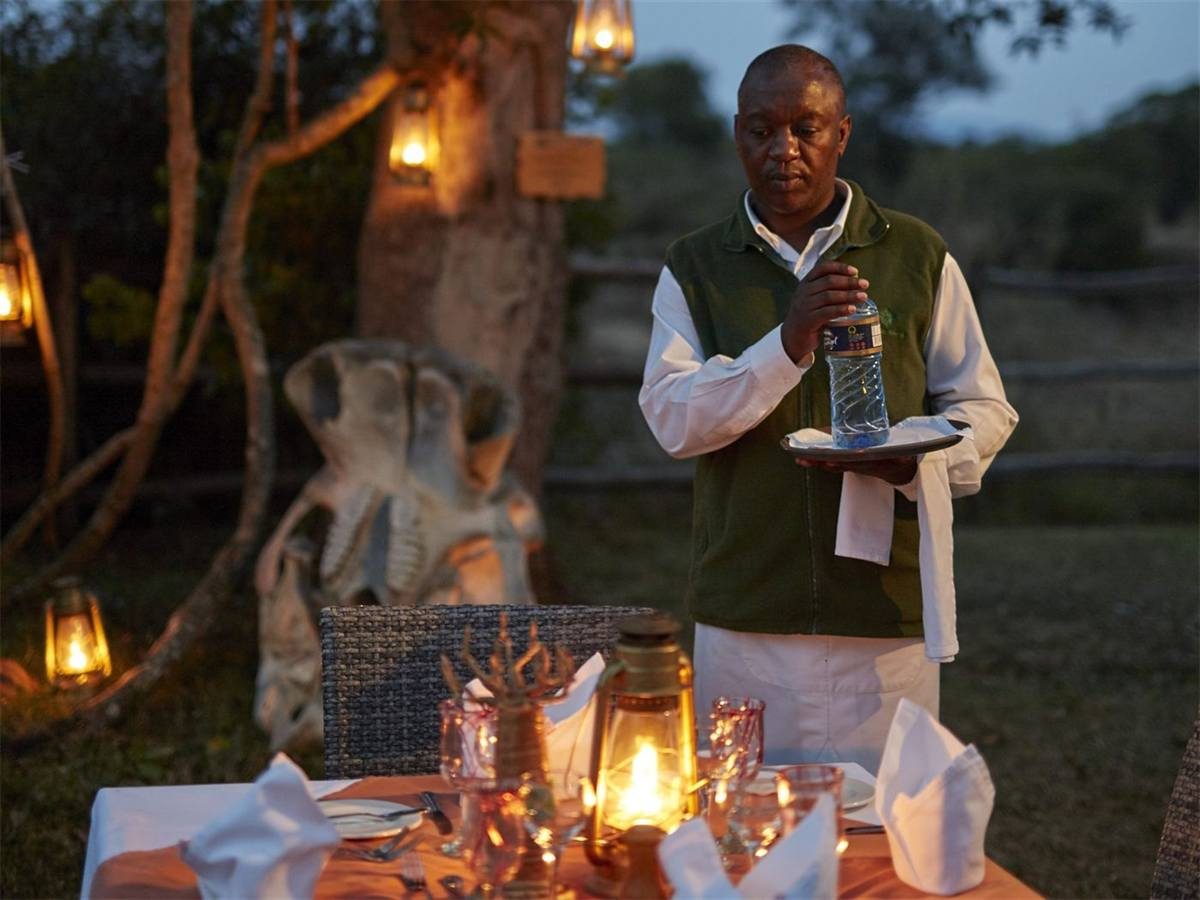 A private table laid with candles and linen out in the bush