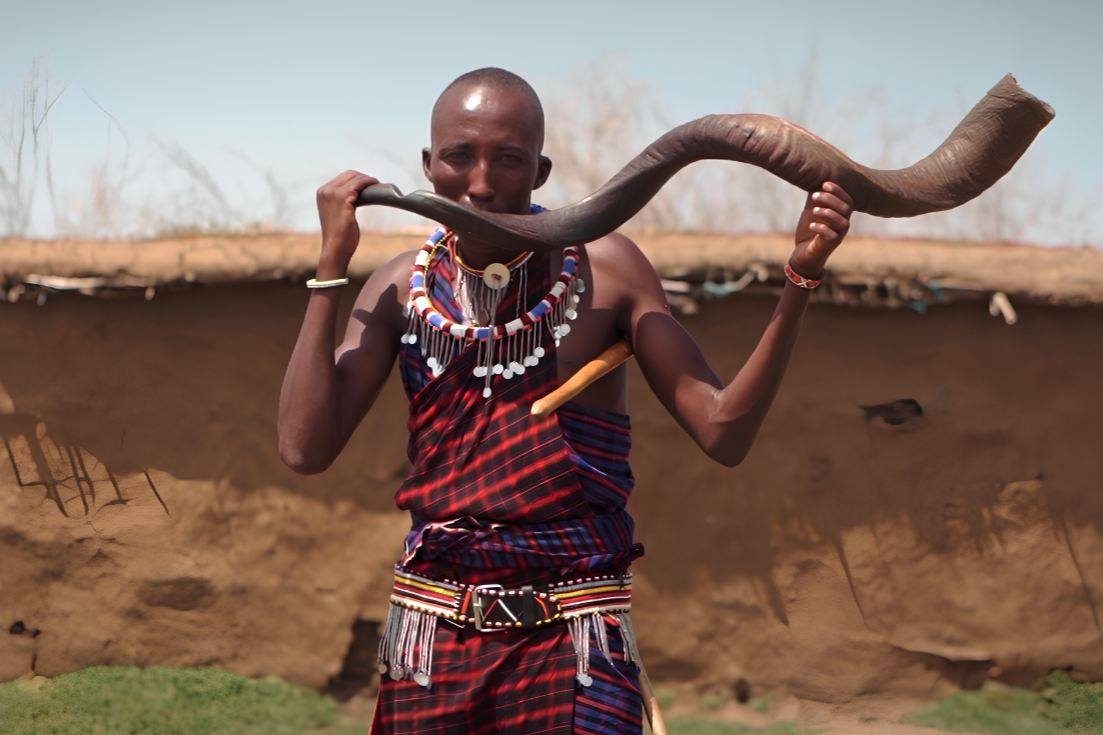Maasai villagers in traditional dress outside a boma