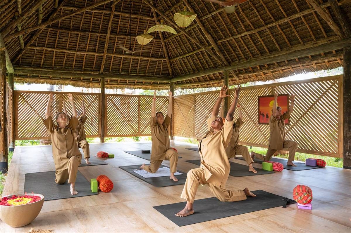 A guided yoga class on the lawn above the beach