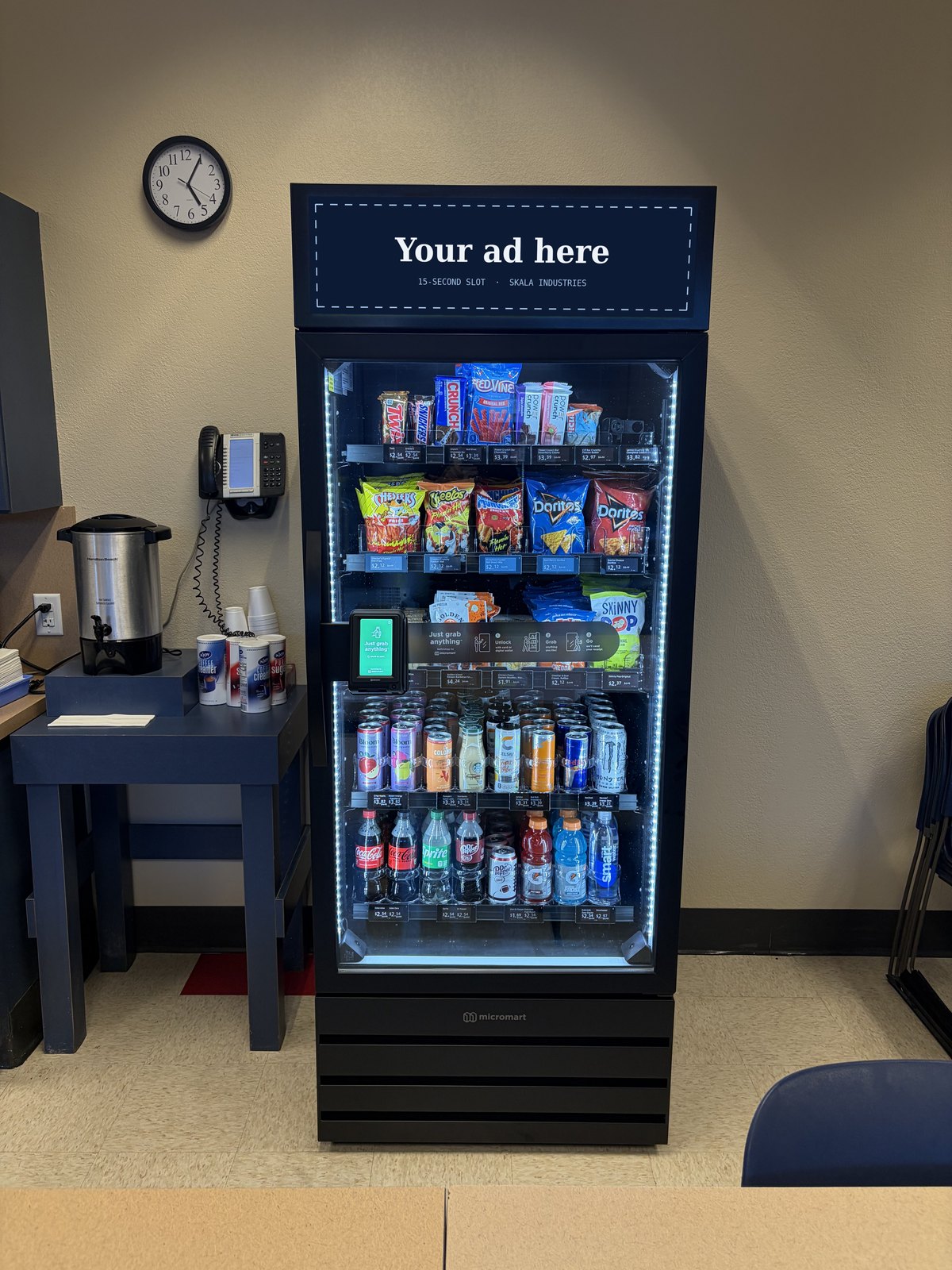 A Micromart AI smart cooler with &ldquo;Your ad here&rdquo; on its digital header screen.
