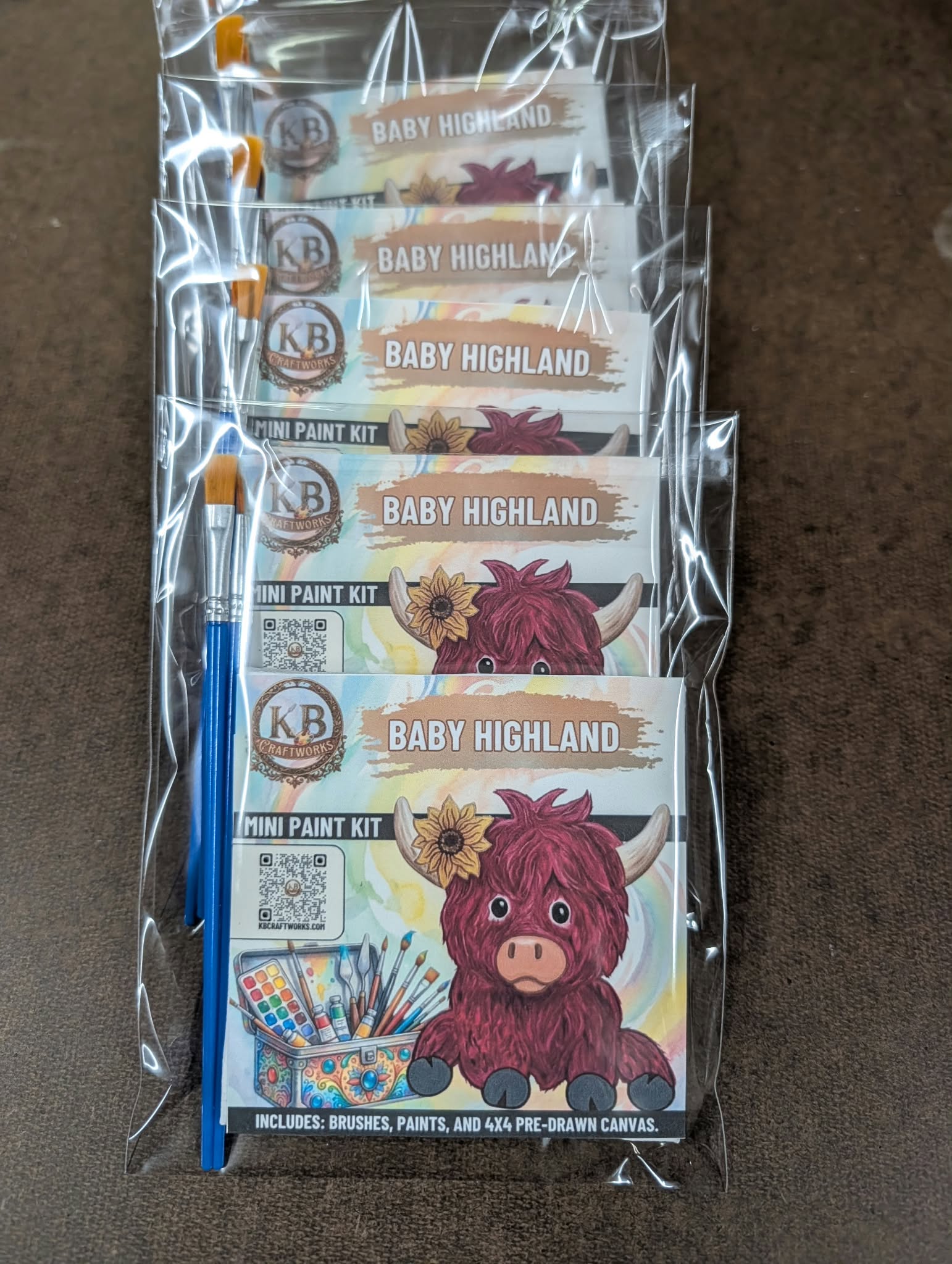 A stack of packaged Baby Highland mini paint kits ready to donate