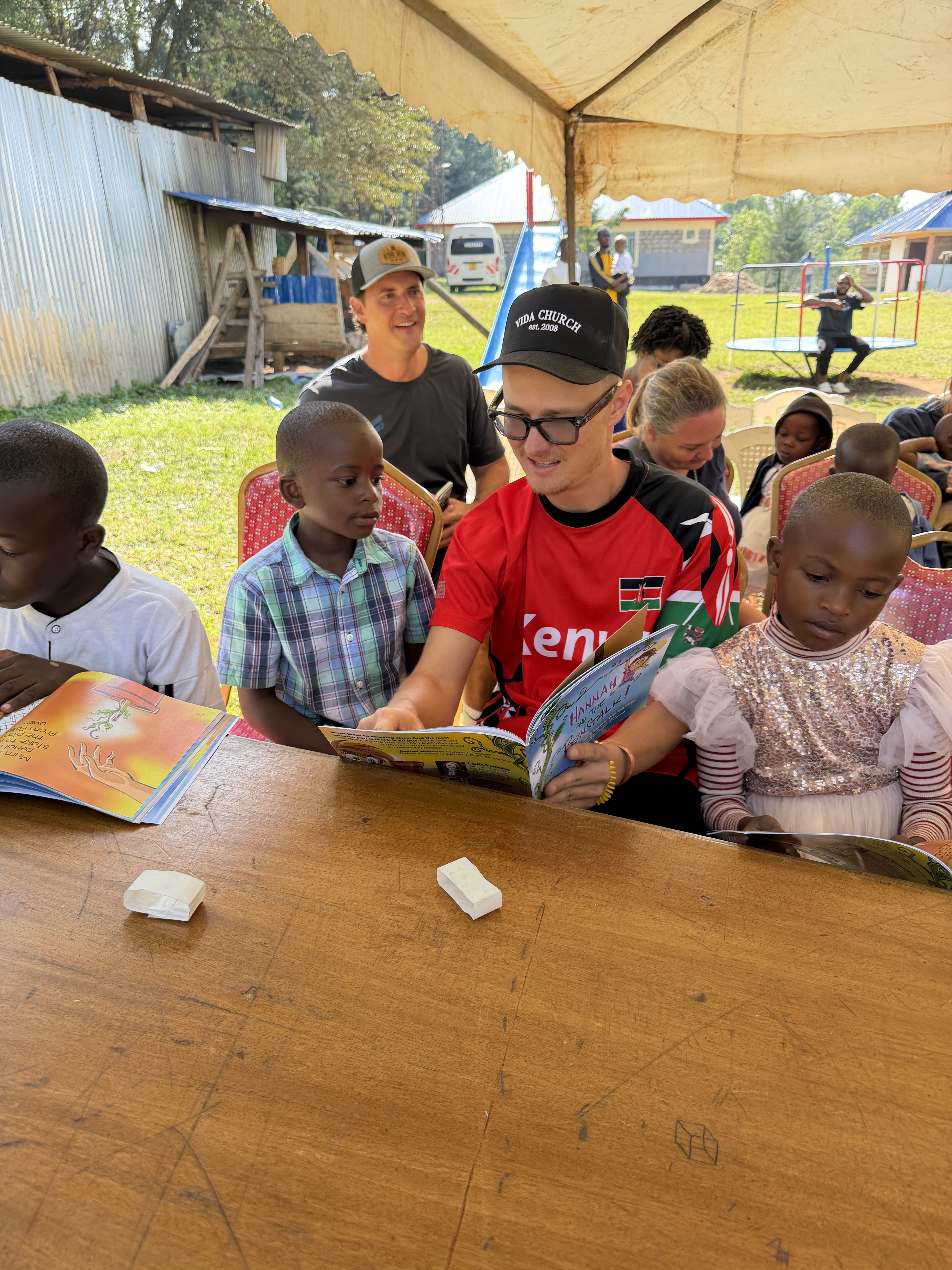 Two girls reading books together at a KOP gathering