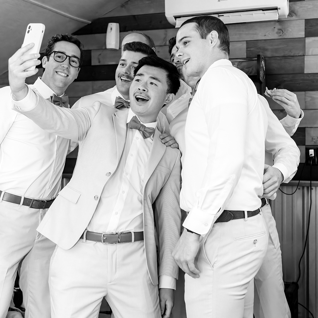 Groomsmen taking a selfie while getting ready for a wedding. 